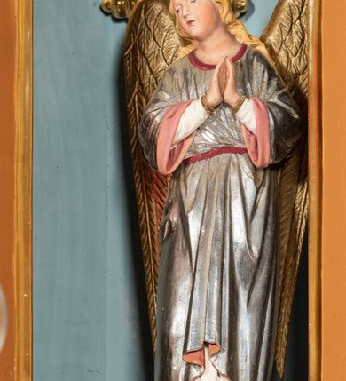 Zdjęcie nr 62: Nastawa ołtarzowa architektoniczna, jednoosiowa, jednokondygnacyjna z bramkami i zwieńczeniem, ustawiona na wysokim, dwustrefowym cokole. Ołtarz prostopadłościenny, murowany, umieszczony w drewnianej obudowie. Antependium ujęte ramą dekorowaną plecionką, podzielone na trzy pola: w środkowym płaskorzeźbione przedstawienie Ostatniej Wieczerzy według Leonarda da Vinci, a po bokach ornament roślinny o wertykalnym układzie.

Tabernakulum architektoniczne, jednokondygnacyjne, trójosiowe, ustawione na zdwojonym na cokole z dwoma zwieńczeniami na osiach skrajnych. Osie wydzielone są parami kolumn o kapitelach kompozytowych, oś środkowa wysunięta do przodu. Podpory dźwigają pełne belkowanie wyłamane na ich linii, przerwane nad polem środkowym, gdzie kolumny dźwigają przerwany półkolisty przyczółek połączony z łukiem gzymsu, nad nim ustawiona jest rzeźba Baranka leżącego na księdze z siedmioma pieczęciami. W polu środkowym dwuskrzydłowe drzwiczki do metalowego tabernakulum ujęte ramą w formie stojącego prostokąta, zamkniętego łukiem nadwieszonym z długim uskokiem. Na drzwiczkach znajdują się dwa aplikowane klęczące anioły, powyżej Chrismo w medalionie, otoczonym glorią. W osiach bocznych są nisze zamknięte konchami z figurkami aniołów, zamknięte zwieńczeniami w formie stojących prostokątów z falistym gzymsem i gałązkami lilii na szczycie; w polu srebrzone, owalne medaliony. Po bokach kondygnacji na wolutowych uszach oraz po bokach zwieńczeń znajdują się wazony ze słonecznikami. Cokół zdobiony jest ornamentem akantowym.

Kondygnacja ujęta jest dwiema parami kolumn o kapitelach kompozytowych oraz stojącą między nimi parą filarów. Podpory dźwigają pełne belkowanie o silnie wysuniętym gzymsie, wyłamane na osiach bocznych, z podwieszonymi szyszkami na tle filarów; przerwane nad polem środkowym. W centrum pole w formie stojącego prostokąta ujęte ramą dekorowaną ornamentem roślinnym z płaskorzeźbionym przedstawieniem Matki Boskiej z Dzieciątkiem. Na zasuwie obrazy: „Najświętsze Serce Pana Jezusa”, „Zwiastowanie” oraz „Św. Mikołaj”. Nad bramkami oraz pomiędzy kolumnami ustawione są rzeźby. Od lewej kolejno: św. Andrzej, św. Wojciech, św. Stanisław i na końcu po prawej św. Tomasz. Nad polem głównym znajduje się przeszklony prześwit w formie półkola z rzeźbioną gołębicą Ducha Świętego na tle glorii. Powyżej pole zamknięte półkoliście fragmentem gzymsu z rzeźbionym popiersiem błogosławiącego Boga Ojca pośród obłoków. Zwieńczenie w formie zbliżonej do stojącego prostokąta o wklęsłych bokach z gzymsem i z podwieszonym lambrekinem oraz kotarami spływającymi na boki. W polu przeszklony prześwit w formie kwadratu zamkniętego łukiem nadwieszonym z rzeźbionym monogramem Marii na tle glorii. Po bokach zwieńczenia ustawione są dwie duże figury klęczących aniołów.

Bramki po bokach ołtarza ustawione są na wysokości cokołu nastawy; przejścia ujęte są parą kanelowanych pilastrów, zamknięte łukiem utworzonym z dwóch przeciwstawnych wolut wspierających wieńczące cokoły. Przejścia w formie wydłużonego stojącego prostokąta zamkniętego łukiem półkolistym nadwieszonym.

Całość ołtarza oprócz tabernakulum dekorowana jest ornamentem małżowinowo-chrząstkowym. Uszy flankujące kondygnację utworzone są również z ornamentu małżowinowo-chrząstkowego. Na zamknięciu zwieńczenia znajdują się dwie uskrzydlone główki anielskie skierowane na wprost z podwieszonymi u szyi chustami. Struktura ołtarza polichromowana jest w kolorze brązowym ze złoconymi kolumnami, ornamentyką i profilami, detale srebrzone.