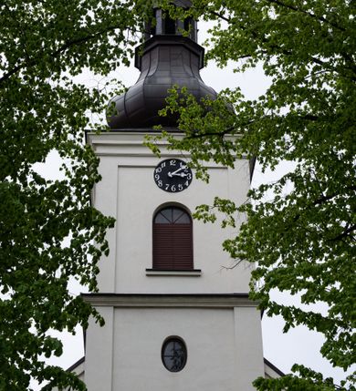 Zdjęcie nr 10: Kościół usytuowany jest w południowo-wschodniej części wsi, otoczony kamiennym murem, otynkowanym, krytym betonową płytą, w który wbudowano współczesne stacje drogi krzyżowej. Na plac kościelny prowadzą trzy bramy. Główna brama znajduje się w murze od strony zachodniej, nakryta jest ostrołukową arkadą. Dwie mniejsze bramy zlokalizowane są od strony południowej oraz od strony wschodniej. Na placu przed kościołem stoi pomnik z 1911 roku wystawiony na pamiątkę księdza Wojciecha Blaszyńskiego i działacza ludowego Stanisława Stojałowskiego. 
Świątynia jest orientowana, murowana, jednonawowa z węższym i krótkim prezbiterium, zamkniętym półkoliście oraz z wieżą na zakończeniu nawy. Do prezbiterium przylega zakrystia od północy i skarbczyk od południa. Od strony południowej dobudowana jest również niska kruchta. Wnętrze trójprzęsłowej nawy rozczłonkowane jest filarami przyściennymi wspierającymi sklepienie żagielkowe. Chór muzyczny trójarkadowy, wsparty na dwóch filarach. W ścianach korpusu nawowego znajdują się głębokie wnęki, w których umieszczone są prostokątne otwory okienne zamknięte półkolistym łukiem, po trzy od strony północnej i południowej; takie same okno znajduje się również w apsydzie od strony południowej oraz na chórze od strony zachodniej. Ponadto w apsydzie na wysokości zwieńczenia ołtarza głównego umieszczone jest małe, okrągłe okno. W kruchcie, skarbczyku i zakrystii okna są prostokątne. Drzwi główne dwuskrzydłowe, drewniane z metalowymi okuciami, zabezpieczone od wewnątrz dwiema żelaznymi zaporami umocowanymi w murze. Podobne drzwi znajdują się od strony południowej z kruchty. 
Fasada kościoła jest płaska, zakończona gzymsem z wysuniętą do przodu trójkondygnacyjną wieżą, nakrytą baniastym hełmem z latarnią. Drugie piętro wieży połączone jest z fasadą prostymi spływami. Przy wejściu na wysokich cokołach ustawione są rzeźby świętych Piotra i Pawła. 
Kościoł nakryty jest dachem dwuspadowym, na skrzyżowaniu nawy z prezbiterium umieszczona jest sygnaturka z hełmem baniastym z latarnią. 
