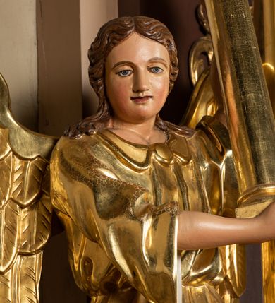 Zdjęcie nr 27: Nastawa ołtarzowa architektoniczna, jednoosiowa i jednokondygnacyjna. Ołtarz prostopadłościenny, drewniany, z drewnianą mensą i z marmurowym portatylem. Antepedium w formie prostokąta ujętego profilowaną ramą. W polu płycina o narożach zdobionych płaskorzeźbioną dekoracją roślinną złożoną z liści stylizowanego akantu oraz umieszczonym w polu veraikonem na tle obłoków i w promienistej glorii. Tabernakulum w kształcie prostopadłościennej skrzynki na niskim cokole, flankowane dwiema kolumnami ustawionymi pod kątem, zamknięte od góry prostym belkowaniem, pośrodku nadwieszonym. Na drzwiczkach płycina w kształcie stojącego prostokąta, zamkniętego łukiem półkolistym, ujęta profilowaną ramą, w polu której umieszczony jest płaskorzeźbiony kielich z hostią.

Retabulum ustawione na podwójnym cokole, flankowane parą zdwojonych pilastrów i ustawionych przed nimi dwiema kolumnami. Podpory dźwigają wyłamane na osi belkowanie z ustawionymi na bokach rzeźbami aniołków z arma Christi (włóczniami). Kolumny wspierają się na bazach, trzony mają gładkie i złocone, a kapitele kompozytowe. Po bokach ołtarza na niskich cokołach ustawione są rzeźby aniołów z narzędziami męki Pańskiej w dłoniach: kolumną biczowania po lewej stronie i włócznią po prawej stronie. W polu, w głębokiej wnęce ujętej szeroką, profilowaną ramą umieszczony jest późnobarokowy krucyfiks na tle malowanej Golgoty i postaci Matki Boskiej, św. Jana Ewangelisty i św. Weroniki. Wnęka od wewnątrz zdobiona jest płaskorzeźbioną winną latoroślą. Cokół dekorowany jest prostokątnymi po bokach płycinami, wypełnionymi stylizowanym akantem. Belkowanie zdobione wicią liści akantu, imposty rozetkami. W zwieńczeniu monumentalna promienista gloria złożona z wiązek promieni o nierównej długości z monogramem Chrystusa na niebieskim tle w polu, otoczonym wieńcem z obłoków. Struktura polichromowana w kolorze jasnego, delikatnego fioletu, płyciny, filary i detale w odcieniu delikatnie ciemniejszym; ornamentyka i profilowania złocone i srebrzone.


