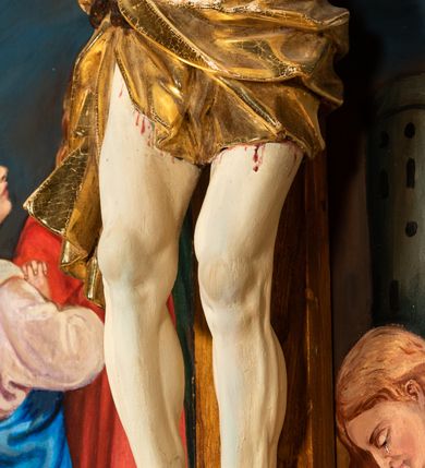 Zdjęcie nr 5: Krucyfiks w typie Cristo morte; postać  Chrystusa umarłego przybitego do krzyża trzema gwoździami. Sylwetka w delikatnym zwisie, o silnie zaznaczonej anatomii ciała, z podkreśloną linią żeber i zaznaczonymi śladami męki. Perizonium w formie tkaniny przewiązanej na sznurze na prawym boku, sięgające kolan i odsłaniające prawe udo. Twarz Jezusa podłużna opadająca na prawe ramię, okolona zarostem; oczy zamknięte, nos podłużny, usta delikatnie otwarte; włosy długie spływające na prawe ramię, na głowie zielona korona cierniowa. Krzyż drewniany, prosty. Nad głową Chrystusa zawieszona tabliczka w kształcie kartusza zdobionego ornamentem okuciowym z napisem „I.N.R.I.” Partie ciała polichromowane naturalistycznie, perizonium złocone.




