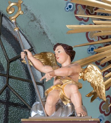 Zdjęcie nr 17: Nastawa ołtarzowa architektoniczna, jednoosiowa i jednokondygnacyjna. Ołtarz prostopadłościenny, drewniany z drewnianą mensą i z marmurowym portatylem. Antepedium w formie prostokąta ujętego profilowaną ramą. W polu płycina o narożach zdobionych płaskorzeźbioną dekoracją roślinną złożoną z liści stylizowanego akantu oraz umieszczonym w polu Barankiem Paschalnym na księdze z siedmioma pieczęciami na czerwonym tle w otoczeniu obłoków i promienistej glorii. Tabernakulum w kształcie prostopadłościennej skrzynki na niskim cokole, flankowane dwiema kolumnami ustawionymi pod kątem, zamknięte od góry prostym belkowaniem, pośrodku nadwieszonym. Na drzwiczkach płycina w kształcie stojącego prostokąta, zamkniętego łukiem półkolistym, ujęta profilowaną ramą, w polu umieszczony jest płaskorzeźbiony kielich z hostią.

Retabulum ustawione na podwójnym cokole, flankowane parą zdwojonych pilastrów i ustawionych przed nimi dwiema kolumnami. Podpory dźwigają wyłamane na osi belkowanie z ustawionymi na bokach rzeźbami aniołków, które trzymają w dłoniach pastorał oraz infułę. Kolumny wspierają się na bazach, trzony mają gładkie i złocone, a kapitele kompozytowe. Po bokach ołtarza na niskich cokołach ustawione są rzeźby: św. Piotra po lewej i św. Pawła po prawej stronie. W polu, w głębokiej wnęce ujętej szeroką, profilowaną ramą umieszczony jest obraz Najświętszego Serca Pana Jezusa. Wnęka od wewnątrz zdobiona płaskorzeźbioną winną latoroślą. Cokół dekorowany jest prostokątnymi płycinami, po bokach wypełnionymi stylizowanym akantem, a pośrodku gablotką z wotami. Belkowanie zdobione wicią z liści akantu oraz rozetami na impostach. W zwieńczeniu monumentalna promienista gloria złożona z wiązek promieni o nierównej długości z monogramem maryjnym na niebieskim tle w polu, otoczonym wieńcem z obłoków. Struktura polichromowana w kolorze jasnego, delikatnego fioletu, płyciny, filary i detale w odcieniu delikatnie ciemniejszym; ornamentyka i profilowania złocone i srebrzone.
