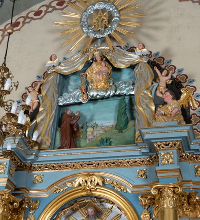 Zdjęcie nr 2: Ołtarz architektoniczny, jednoosiowy, jednokondygnacyjny ze zwieńczeniem. Mensa w kształcie nieregularnego prostopadłościanu, poprzedzona dwoma stopniami. Antepedium w formie prostokątnej płyciny, wewnątrz której w narożach są stylizowane dekoracje kwiatowe, a pośrodku równoramienna gwiazda w kartuszu. Tabernakulum w kształcie prostokątnej skrzynki, flankowane w narożach ustawionymi pod kątem pilastrami w formie liści, podtrzymującymi wyłamujący się gzyms. Drzwiczki zamknięte półkoliście z aplikowanym motywem kielicha oraz medalionem z napisem IHS w niewielkiej glorii. Drzwiczki obite srebrzoną blachą, boki i dekoracje złocone, gzyms w kolorze jasnoniebieskim. 

Cokół nastawy zdobiony kratkowaniem, a po bokach prostokątnymi płycinami ze stylizowaną dekoracją akantową. Retabulum flankowane zdwojoną parą pilastrów i stojącą przed nimi parą kolumn. Podpory dźwigają wyłamane na osi belkowanie. Kolumny ustawione na bazach, trzony gładkie i złocone, wybrzuszone pośrodku, kapitele kompozytowe. W polu głównym w niszy zamkniętej półkolistym łukiem umieszczony jest obraz Matki Boskiej z Dzieciątkiem, a powyżej rzeźba Boga Ojca. Na boku ołtarza znajdują się rzeźby: św. Dominika po lewej i św. Jacka po prawej stronie. Na belkowaniu usadzona jest para aniołków. Zwieńczenie o fantazyjnym kształcie zbliżonym do stojącego prostokąta z płaskorzeźbioną sceną ofiarowania szkaplerza św. Szymonowi Stockowi. U góry zwieńczenia podpięta srebrzona kotara o złoconym brzegu, spływająca na jego boki zwieńczenia. W górnej partii, po bokach para aniołków z wzniesionymi do góry rękami oraz dwie uskrzydlone główki anielskie. Na szczycie nastawy zatknięta jest promienista gloria złożona z wiązek promieni o nierównej długości z monogramem maryjnym otoczonym przez wieniec z obłoków w polu. Po bokach nastawy ołtarzowej umieszczone są uszaki utworzone ze stylizowanego akantu. Polichromia ołtarza w kolorze jasnoniebieskim, dekoracje ornamentalne oraz detale złocone i srebrzone. 
