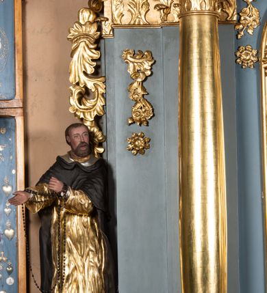 Zdjęcie nr 20: Ołtarz architektoniczny, jednoosiowy, jednokondygnacyjny ze zwieńczeniem. Mensa w kształcie nieregularnego prostopadłościanu, poprzedzona dwoma stopniami. Antepedium w formie prostokątnej płyciny, wewnątrz której w narożach są stylizowane dekoracje kwiatowe, a pośrodku równoramienna gwiazda w kartuszu. Tabernakulum w kształcie prostokątnej skrzynki, flankowane w narożach ustawionymi pod kątem pilastrami w formie liści, podtrzymującymi wyłamujący się gzyms. Drzwiczki zamknięte półkoliście z aplikowanym motywem kielicha oraz medalionem z napisem IHS w niewielkiej glorii. Drzwiczki obite srebrzoną blachą, boki i dekoracje złocone, gzyms w kolorze jasnoniebieskim. 

Cokół nastawy zdobiony kratkowaniem, a po bokach prostokątnymi płycinami ze stylizowaną dekoracją akantową. Retabulum flankowane zdwojoną parą pilastrów i stojącą przed nimi parą kolumn. Podpory dźwigają wyłamane na osi belkowanie. Kolumny ustawione na bazach, trzony gładkie i złocone, wybrzuszone pośrodku, kapitele kompozytowe. W polu głównym w niszy zamkniętej półkolistym łukiem umieszczony jest obraz Matki Boskiej z Dzieciątkiem, a powyżej rzeźba Boga Ojca. Na boku ołtarza znajdują się rzeźby: św. Dominika po lewej i św. Jacka po prawej stronie. Na belkowaniu usadzona jest para aniołków. Zwieńczenie o fantazyjnym kształcie zbliżonym do stojącego prostokąta z płaskorzeźbioną sceną ofiarowania szkaplerza św. Szymonowi Stockowi. U góry zwieńczenia podpięta srebrzona kotara o złoconym brzegu, spływająca na jego boki zwieńczenia. W górnej partii, po bokach para aniołków z wzniesionymi do góry rękami oraz dwie uskrzydlone główki anielskie. Na szczycie nastawy zatknięta jest promienista gloria złożona z wiązek promieni o nierównej długości z monogramem maryjnym otoczonym przez wieniec z obłoków w polu. Po bokach nastawy ołtarzowej umieszczone są uszaki utworzone ze stylizowanego akantu. Polichromia ołtarza w kolorze jasnoniebieskim, dekoracje ornamentalne oraz detale złocone i srebrzone. 
