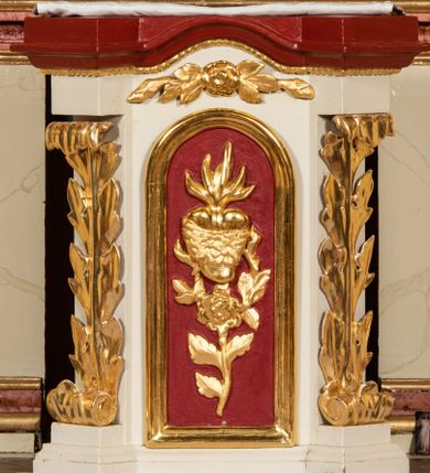 Zdjęcie nr 4: Nastawa ołtarzowa architektoniczna, jednoosiowa, jednokondygnacyjna ze zwieńczeniem. Ołtarz prostopadłościenny, drewniany z drewnianą mensą i z marmurowym portatylem. Antepedium w formie prostokąta ujętego profilowaną ramą. W polu marmoryzowana płycina o narożach zdobionych płaskorzeźbioną dekoracją roślinną złożoną z liści akantu oraz nałożonymi na siebie łacińskim krzyżem z kotwicą i gorejącym sercem oplecionym wicią z róż w polu. Tabernakulum w kształcie prostopadłościennej skrzynki na niskim cokole, flankowane dwoma pilastrami ustawionymi pod kątem, zdobionymi wicią z liści akantu; zamknięte od góry prostym belkowaniem, pośrodku falującym. Na drzwiczkach płycina w kształcie stojącego prostokąta, zamkniętego łukiem półkolistym, ujęta profilowaną ramą, w polu której umieszczone jest płaskorzeźbione gorejące serce osadzone na gałązce róży; tło czerwone.

Retabulum na zdwojonym cokole, flankowane ustawionymi pod kątem w jednej linii parami pilastrów, filarów oraz kolumn na przodzie. Podpory dźwigają wyłamane na osi belkowanie z ustawionymi na bokach rzeźbami aniołków. Trzony filarów są marmoryzowane; trzony kolumn delikatnie zwężające się ku górze, złocone, zdobione pionowymi pasami, co drugi wypełniony pnącą się ku górze rytą wicią z liści dębu lub z liści klonu; kapitele podpór kompozytowe.  Po bokach ołtarza na niskich cokołach ustawione pod kątem rzeźby św. Katarzyny Aleksandryjskiej po lewej i św. Wawrzyńca po prawej stronie. W polu, w głębokiej wnęce ujętej szeroką, profilowaną ramą umieszczony jest obraz św. Józefa z Dzieciątkiem. Wnęka od wewnątrz zdobiona płaskorzeźbioną winną latoroślą. Cokół dekorowany jest prostokątnymi, marmoryzowanymi płycinami; fryz złoconymi rozetami.

Zwieńczenie monumentalne, o fantazyjnym kształcie, po bokach ujęte wolutami zdobionymi liśćmi akantu, zamknięte od góry prostym gzymsem w formie nadwieszonego łuku z zatkniętym na szczycie łacińskim krzyżykiem. W polu, w półkolistej wnęce promienista gloria z dwoma gorejącymi sercami, z których jedno przebite jest mieczem, umieszczonym w otoku z obłoków.

Struktura w kolorze jasnobeżowym, płyciny, filary i detale marmoryzowana w kolorze różowym; ornamentyka i profilowania złocone i srebrzone.

