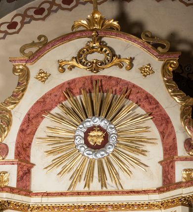 Zdjęcie nr 2: Nastawa ołtarzowa architektoniczna, jednoosiowa, jednokondygnacyjna ze zwieńczeniem. Ołtarz prostopadłościenny, drewniany z drewnianą mensą i z marmurowym portatylem. Antepedium w formie prostokąta ujętego profilowaną ramą. W polu marmoryzowana płycina o narożach zdobionych płaskorzeźbioną dekoracją roślinną złożoną z liści akantu oraz nałożonymi na siebie łacińskim krzyżem z kotwicą i gorejącym sercem oplecionym wicią z róż w polu. Tabernakulum w kształcie prostopadłościennej skrzynki na niskim cokole, flankowane dwoma pilastrami ustawionymi pod kątem, zdobionymi wicią z liści akantu; zamknięte od góry prostym belkowaniem, pośrodku falującym. Na drzwiczkach płycina w kształcie stojącego prostokąta, zamkniętego łukiem półkolistym, ujęta profilowaną ramą, w polu której umieszczone jest płaskorzeźbione gorejące serce osadzone na gałązce róży; tło czerwone.

Retabulum na zdwojonym cokole, flankowane ustawionymi pod kątem w jednej linii parami pilastrów, filarów oraz kolumn na przodzie. Podpory dźwigają wyłamane na osi belkowanie z ustawionymi na bokach rzeźbami aniołków. Trzony filarów są marmoryzowane; trzony kolumn delikatnie zwężające się ku górze, złocone, zdobione pionowymi pasami, co drugi wypełniony pnącą się ku górze rytą wicią z liści dębu lub z liści klonu; kapitele podpór kompozytowe.  Po bokach ołtarza na niskich cokołach ustawione pod kątem rzeźby św. Katarzyny Aleksandryjskiej po lewej i św. Wawrzyńca po prawej stronie. W polu, w głębokiej wnęce ujętej szeroką, profilowaną ramą umieszczony jest obraz św. Józefa z Dzieciątkiem. Wnęka od wewnątrz zdobiona płaskorzeźbioną winną latoroślą. Cokół dekorowany jest prostokątnymi, marmoryzowanymi płycinami; fryz złoconymi rozetami.

Zwieńczenie monumentalne, o fantazyjnym kształcie, po bokach ujęte wolutami zdobionymi liśćmi akantu, zamknięte od góry prostym gzymsem w formie nadwieszonego łuku z zatkniętym na szczycie łacińskim krzyżykiem. W polu, w półkolistej wnęce promienista gloria z dwoma gorejącymi sercami, z których jedno przebite jest mieczem, umieszczonym w otoku z obłoków.

Struktura w kolorze jasnobeżowym, płyciny, filary i detale marmoryzowana w kolorze różowym; ornamentyka i profilowania złocone i srebrzone.

