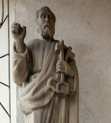 Zdjęcie nr 1: Rzeźba przedstawiająca św. Piotra, wolnostojąca, pełna, ustawiona na prostopadłościennym cokole. Święty ukazany w delikatnym kontrapoście z prawą nogą ugiętą w kolanie, prawą ręką ugiętą w łokciu i uniesioną do góry, w lewej przyciśniętej do piersi trzyma dwa klucze. Twarz podłużna, okolona krótką brodą, usta delikatnie rozchylone, nos długi i prosty, włosy krótkie z kępką włosów nad czołem. Święty ubrany jest w długą suknię z długimi rękawami, przewiązaną w talii oraz płaszcz przerzucony przez lewe ramię i spływający połą wzdłuż lewego boku. Draperia szat sztywna, biegnąca równoległymi fałdami w dół. 