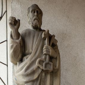 Zdjęcie nr 1: Rzeźba przedstawiająca św. Piotra, wolnostojąca, pełna, ustawiona na prostopadłościennym cokole. Święty ukazany w delikatnym kontrapoście z prawą nogą ugiętą w kolanie, prawą ręką ugiętą w łokciu i uniesioną do góry, w lewej przyciśniętej do piersi trzyma dwa klucze. Twarz podłużna, okolona krótką brodą, usta delikatnie rozchylone, nos długi i prosty, włosy krótkie z kępką włosów nad czołem. Święty ubrany jest w długą suknię z długimi rękawami, przewiązaną w talii oraz płaszcz przerzucony przez lewe ramię i spływający połą wzdłuż lewego boku. Draperia szat sztywna, biegnąca równoległymi fałdami w dół. 