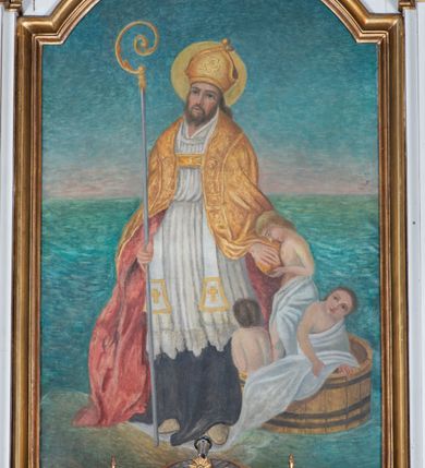 Zdjęcie nr 8: Mensa ołtarzowa kamienna, wsparta na dwóch konsolach, o profilowanym brzegu z inskrypcją „S[AN]CTI MARTYRES ADALBERTE EPISCOPE ET ANDREA SACERDOS ORATE PRO NOBIS”. Tabernakulum w formie drewnianej, prostopadłościennej skrzynki obitej fakturowaną blachą. Ścianka frontowa ujęta parą kolumienek, podtrzymujących niepełne belkowanie; drzwiczki dwuskrzydłowe z aplikowanymi aniołami otaczającymi hostię w glorii. Tron wystawienia drewniany, w formie baldachimu podtrzymywanego na tylnej ściance, z upiętymi po bokach kotarami z frędzlami i chwostami.

Nastawa ołtarzowa architektoniczna, jednoosiowa, jednokondygnacyjna ze zwieńczeniem, ustawiona na dwustrefowym cokole, dolnym murowanym. Kondygnacja ujęta dwiema parami pilastrów o kanelowanych trzonach i stylizowanych kapitelach kompozytowych, na tle skrajnej pary dwie kolumny o kapitelach kompozytowych. Podpory wspierają pełne belkowanie wyłamane na ich osi oraz przerwany, półkolisty przyczółek na osi zewnętrznej pary. W polu środkowym płytka nisza w formie stojącego prostokąta zamknięta łukiem odcinkowym nadwieszonym, ujęta profilowaną ramą z wpisaną ornamentalną ramą, wewnątrz znacznie mniejszy obraz w formie stojącego prostokąta z przedstawieniem Matki Boskiej z Dzieciątkiem. Zwieńczenie ustawione na niewielkim cokole, w formie stojącego prostokąta flankowanego parą kanelowanych pilastrów i stojącą przed nimi parą kolumienek, wspierających imposty z wazonami, zamkniętego dwoma falistymi i przeciwstawnie zwróconymi fragmentami gzymsu przechodzącymi w woluty; całość zakończona ornamentalnym szczytem z medalionem. W polu profilowana rama w formie stojącego prostokąta zamkniętego łukiem półkolistym nadwieszonym z przedstawieniem św. Jana Chrzciciela jako dziecka. Górna strefa cokołu oraz fryz dekorowane płycinami z ornamentem roślinnym. W przestrzeni pomiędzy pilastrami kondygnacji zwisy utworzone z pęków owoców i kwiatów, zawieszone na muszli. Struktura polichromowana w kolorze białym, kolumny, profile i ornamentyka złocone.