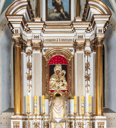 Zdjęcie nr 3: Obraz w kształcie stojącego prostokąta z przedstawieniem Matki Boskiej z Dzieciątkiem. Maria ukazana w półpostaci z Dzieciątkiem na lewym ręku. Dzieciątko zwrócone trzy czwarte w prawo, w pozycji siedzącej, z głową skierowaną w stronę matki, z uniesioną prawą rączką w geście błogosławieństwa, z lewą wspartą na księdze. Twarze o delikatnych rysach, karnacje ciemne. Postacie przybrane złoconą sukienką, ozdobioną małymi gałązkami z drobnymi kwiatkami. Na głowach Marii i Dzieciątka korony zamknięte, dekorowane różnokolorowymi kamieniami. Tło obrazu jednolite, czarne. Obraz umieszczony w wąskiej, prostej i złoconej ramie. Na odwrociu napis „+ / Consecrata. /  I(mmaculata) B(eata) M(aria) V(irgo) / Pin(xit) Cracovie(nsis) / A(nno) D(omini) 1698”.