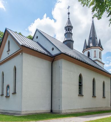Zdjęcie nr 13: Kościół jest usytuowany w centrum wsi Biały Kościół, na północ od głównej drogi z Krakowa do Olkusza. Teren wokół niego jest otoczony wysokim, kamiennym murem, otynkowanym. Główne wejście znajduje się w murze od zachodu z bramką i dwiema furtkami, flankowanymi przez cztery masywne filary, zdobione ostrołukowymi blendami. Na szczycie filarów ustawione są rzeźby św. Mikołaja i św. Stanisława oraz dwa wazony płomieniste po bokach. Na południowy zachód od kościoła wybudowana jest w ogrodzeniu kaplica. Ponadto w murze są jeszcze trzy wnęki, przykryte daszkami, w których umieszczone są figury.

Kościół jest orientowany, murowany, otynkowany. Wnętrze świątyni tworzy niewielkie, prostokątne, jednoprzęsłowe prezbiterium zakończone prostą ścianą i nakryte pozornym sklepieniem krzyżowo-żebrowym. Nawa jest szersza, na planie prostokąta, nakryta drewnianym stropem z kasetonami, oddzielona od prezbiterium szeroką ostrołukową arkadą w ścianie tęczowej. Od południa do prezbiterium przylega założona na planie prostokąta zakrystia ze sklepieniem beczkowym (pozostawiona ze starego kościoła). Do tej części wzdłuż południowej ściany nawy przylegają kruchta oraz nowo wybudowana druga zakrystia. Na zachodniej ścianie nawy chór muzyczny, dostępny klatką schodową od strony nawy.

Nawę oświetlają umieszczone w południowych i północnych ścianach prostokątne, zamknięte ostrołukowo, rozglifione okna. Na ścianie północnej trzy, a na południowej dwa oraz jedno mniejsze, usytuowane pośrodku nawy nad kruchtą. W prezbiterium są dwa okna na ścianie wschodniej. Wszystkie otwory okienne w kościele wypełnione są witrażami. Do świątyni prowadzą trzy wejścia: główne od strony zachodniej, drugie przez zakrystię od strony wschodniej oraz trzecie przez kruchtę od południa. Wejście główne prowadzi poprzez dwuskrzydłowe drzwi z kruchty pod wieżą. Drzwi między kruchtą a nawą główną są dębowe, przeszklone; za nimi zamocowana jest metalowa krata. 

W zewnętrznej elewacji kościoła widoczny jest niewysoki, kamienny cokół, wykonany z regularnych ciosów kamienia. Prezbiterium niższe od nawy. We wschodniej ścianie, pomiędzy dwoma oknami znajduje się niewielka wnęka, zakończona łukiem półkolistym z figurą Matki Boskiej w polu; powyżej w trójkątnym szczycie umieszczone jest niewielkie, wąskie okienko zakończone łukiem ostrołukowym. Elewacje są bez podziałów architektonicznych. Do zachodniej fasady kościoła dostawiona jest założona na planie kwadratu trójkondygnacyjna wieża-dzwonnica. Poszczególne kondygnacje ustawione są na niskich cokołach i zamknięte profilowanymi gzymsami. W dolnej kondygnacji na osi kościoła, prostokątne wejście do kruchty zaakcentowane rozglifionym portalem w kształcie ostrołukowej arkady i dwustopniowymi schodami. W drugiej kondygnacji ostrołukowe okno zamknięte parą ostrołukowych blend, połączonych jednym parapetem, od góry zamknięte dekoracyjnym trójarkadkowym fryzem. Trzecia kondygnacja ośmioboczna, w każdej ze ścian naprzemiennie ostrołukowe okno lub blenda. Całość nakryta ośmiobocznym, smukłym dachem wieżowym, zakończonym krzyżem osadzonym na kuli; u dołu artykułowanym ośmioma, małymi wieżyczkami. Po bokach wieży, na ścianie zachodniej nawy dwie prostokątne blendy, zamknięte ostrołukowo. Prezbiterium i nawa przykryte stromymi dachami dwuspadowymi. Wieżyczka na sygnaturkę ośmioboczna z latarnią. 

