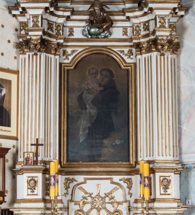 Zdjęcie nr 1: Nastawa ołtarzowa architektoniczna, jednoosiowa, jednokondygnacyjna ze zwieńczeniem, ustawiona na trójstrefowym cokole, dolnym murowanym. Mensa ołtarzowa kamienna, wsparta na dwóch konsolach, o profilowanym brzegu z inskrypcją „S(ANC)TI MART(YRES) STANISLAE EP(ISCOPE) CRACOVIAEN(SI) ET THOMA EP(ISCOPE) CANTUARIEN(SI) ORATE PRO NOBIS”. Tabernakulum w formie  drewnianej, prostopadłościennej skrzynki, ustawione na niskim cokole, zamknięte niewielkim gzymsem. Drzwiczki dwuskrzydłowe z aplikowanymi literami alfa i omega. Cokół nastawy zdobiony w dolnej partii parą konsolek z liśćmi akantu, powyżej prostokątne płyciny z rzeźbionymi główkami aniołków. Pośrodku cokół dekorowany prostokątną płyciną zamkniętą łukiem dwuramiennym z uskokiem. W polu płaskorzeźbiona dekoracja złożona z korony cierniowej na tle promienistej glorii oraz stylizowanych wici roślinnych akantu oraz rocaille’u.

Kondygnacja ujęta zwielokrotnionymi parami pilastrów o kanelowanych trzonach i stylizowanych kapitelach kompozytowych. Podpory wspierają pełne belkowanie wyłamane na ich osi oraz przerwany, półkolisty przyczółek na osi zewnętrznej. W polu środkowym płytka nisza w formie stojącego prostokąta zamknięta łukiem odcinkowym nadwieszonym, ujęta profilowaną ramą, wewnątrz obraz z przedstawieniem św. Antoniego Padewskiego. Zwieńczenie ustawione na niewielkim cokole, w formie stojącego prostokąta flankowanego parą kanelowanych pilastrów, wspierających profilowany gzyms i ustawione po bokach wazony. Całość zakończona ornamentalnym szczytem ze stylizowaną muszlą palmetową. W polu płaskorzeźbiona gołębica Ducha Świętego na tle promienistej glorii. Poniżej w partii fryzu rzeźba Boga Ojca. Po bokach zwieńczenia spływy wolutowe ozdobione kampanulami. Struktura polichromowana w kolorze białym, kolumny, profile i ornamentyka złocone, detale srebrzone.
