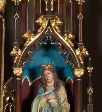 Zdjęcie nr 3: Nastawa architektoniczna, trójosiowa, jednokondygnacyjna ze zwieńczeniem, ustawiona na wysokiej predelli. Ołtarz w formie płytkiej skrzyni ustawionej na stopniu, dekorowanej z przodu dwiema półkolumienkami oraz trzema płycinami – dwiema z blendami i środkowej z godłem franciszkańskim. Mensa drewniana, wysunięta do przodu, wsparta na dwóch kolumnach. Predella dekorowana płycinami z blendami. Na jej tle, na mensie stoi figura św. Franciszka. Osie nastawy wydzielone trzema parami kolumienek podtrzymujących wimpergi z pinaklami, zakończone szczytami. Oś środkowa najwyższa, w jej polu obraz św. Ludwika w formie stojącego prostokąta zamkniętego łukiem trójlistnym ostrym, w prostej ramie dekorowanej na łuku ornamentem roślinnym. Zakończona szczytem w formie wieżyczki z przyporami i z ażurowymi blendami, zwieńczonej pinaklami dekorowanymi kwiatonami. Na osiach bocznych nisze z figurami św. Elżbiety i św. Katarzyny Aleksandryjskiej; flankowane ażurowymi blendami i maswerkami, po zewnętrznej stronie z pinaklami. Osie zakończone szczytami w formie wieżyczek z przyporami i ażurowymi blendami oraz pinaklami dekorowanymi kwiatonami. 
Struktura nastawy pokryta ciemnobrązową politurą, ornamentyka i profile złocone, wnętrza nisz polichromowane w kolorze czerwonym i niebieskim. 
