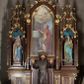 Zdjęcie nr 1: Nastawa architektoniczna, trójosiowa, jednokondygnacyjna ze zwieńczeniem, ustawiona na wysokiej predelli. Ołtarz w formie płytkiej skrzyni ustawionej na stopniu, dekorowanej z przodu dwiema półkolumienkami oraz trzema płycinami – dwiema z blendami i środkowej z godłem franciszkańskim. Mensa drewniana, wysunięta do przodu, wsparta na dwóch kolumnach. Predella dekorowana płycinami z blendami. Na jej tle, na mensie stoi figura św. Franciszka. Osie nastawy wydzielone trzema parami kolumienek podtrzymujących wimpergi z pinaklami, zakończone szczytami. Oś środkowa najwyższa, w jej polu obraz św. Ludwika w formie stojącego prostokąta zamkniętego łukiem trójlistnym ostrym, w prostej ramie dekorowanej na łuku ornamentem roślinnym. Zakończona szczytem w formie wieżyczki z przyporami i z ażurowymi blendami, zwieńczonej pinaklami dekorowanymi kwiatonami. Na osiach bocznych nisze z figurami św. Elżbiety i św. Katarzyny Aleksandryjskiej; flankowane ażurowymi blendami i maswerkami, po zewnętrznej stronie z pinaklami. Osie zakończone szczytami w formie wieżyczek z przyporami i ażurowymi blendami oraz pinaklami dekorowanymi kwiatonami. 
Struktura nastawy pokryta ciemnobrązową politurą, ornamentyka i profile złocone, wnętrza nisz polichromowane w kolorze czerwonym i niebieskim. 
