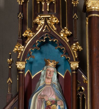 Zdjęcie nr 8: Nastawa architektoniczna, trójosiowa, jednokondygnacyjna ze zwieńczeniem, ustawiona na wysokiej predelli. Ołtarz w formie płytkiej skrzyni ustawionej na stopniu, dekorowanej z przodu dwiema półkolumienkami oraz trzema płycinami – dwiema z blendami i środkowej z godłem franciszkańskim. Mensa drewniana, wysunięta do przodu, wsparta na dwóch kolumnach. Predella dekorowana płycinami z blendami. Na jej tle, na mensie stoi figura św. Franciszka. Osie nastawy wydzielone trzema parami kolumienek podtrzymujących wimpergi z pinaklami, zakończone szczytami. Oś środkowa najwyższa, w jej polu obraz św. Ludwika w formie stojącego prostokąta zamkniętego łukiem trójlistnym ostrym, w prostej ramie dekorowanej na łuku ornamentem roślinnym. Zakończona szczytem w formie wieżyczki z przyporami i z ażurowymi blendami, zwieńczonej pinaklami dekorowanymi kwiatonami. Na osiach bocznych nisze z figurami św. Elżbiety i św. Katarzyny Aleksandryjskiej; flankowane ażurowymi blendami i maswerkami, po zewnętrznej stronie z pinaklami. Osie zakończone szczytami w formie wieżyczek z przyporami i ażurowymi blendami oraz pinaklami dekorowanymi kwiatonami. 
Struktura nastawy pokryta ciemnobrązową politurą, ornamentyka i profile złocone, wnętrza nisz polichromowane w kolorze czerwonym i niebieskim. 
