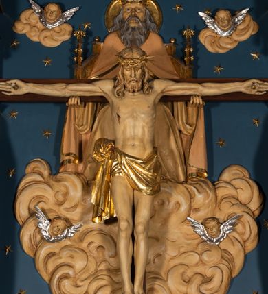 Zdjęcie nr 4: Nastawa architektoniczna, jednoosiowa, jednokondygnacyjna, ze zwieńczeniem, ustawiona na wysokim cokole. Ołtarz ustawiony na pięciostopniowej kamiennej podstawie; granitowy, prostopadłościenny, z monogramem IHS na froncie, mensa granitowa. Na nim drewniane tabernakulum w formie prostopadłościennej skrzynki, flankowane parą kolumienek, zamknięte od góry profilowanym gzymsem. Na ściance frontowej wysunięte do przodu metalowe drzwiczki w oprawie architektonicznej na niskim cokole, zamknięte od góry prostym gzymsem. Na drzwiczkach kielich z hostią, w płycinie o kształcie prostokąta stojącego zamkniętego łukiem trójlistnym ostrym. 
Nastawa flankowana dwiema dwukondygnacyjnymi wieżyczkami na planie ośmioboku z figurami św. Jana Ewangelisty i św. Piotra w pierwszej kondygnacji oraz figurami aniołów w drugiej. Figury apostołów ustawione są na ośmiobocznych wspornikach zdobionych od dołu arkadowaniem z kwiatonami, podtrzymywanych przez ośmioboczne kolumienki, flankujące kamienny ołtarz. Nad figurami ośmioboczne baldachimy zdobione od dołu arkadowaniem z kwiatonami, stanowiące podstawę dla figur aniołów, które zwieńczone są analogicznymi ośmiobocznymi baldachimami i rozbudowanymi pinaklami. W polu środkowym rzeźbiona Trójca Święta ukazana jako Tron łaski pośród obłoków i uskrzydlonych główek anielskich. Nad nią duży, ośmioboczny baldachim, zdobiony od dołu arkadowaniem, zakończonym kwiatonami, dekorowany maswerkami, wimpergami i kwiatonami, naprzemiennie z pinaklami, który stanowi podstawę wieżyczki wieńczącej ołtarz. W jej polu ustawiona figura Matki Boskiej, nad nią ośmioboczny baldachim zdobiony od dołu arkadowaniem i kwiatonami, zakończony dużym pinaklem dekorowanym żabkami. Nastawa flankowana uszami w formie przypór dekorowanych maswerkiem i wąskimi kolumienkami z pinaklami. 
Struktura politurowana w kolorze ciemnobrązowym, detale i ornamentyka złocone, tło pola głównego oraz podniebienia baldachimów błękitne.