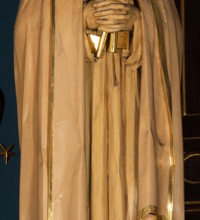 Zdjęcie nr 9: Nastawa architektoniczna, jednoosiowa, jednokondygnacyjna, ze zwieńczeniem, ustawiona na wysokim cokole. Ołtarz ustawiony na pięciostopniowej kamiennej podstawie; granitowy, prostopadłościenny, z monogramem IHS na froncie, mensa granitowa. Na nim drewniane tabernakulum w formie prostopadłościennej skrzynki, flankowane parą kolumienek, zamknięte od góry profilowanym gzymsem. Na ściance frontowej wysunięte do przodu metalowe drzwiczki w oprawie architektonicznej na niskim cokole, zamknięte od góry prostym gzymsem. Na drzwiczkach kielich z hostią, w płycinie o kształcie prostokąta stojącego zamkniętego łukiem trójlistnym ostrym. 
Nastawa flankowana dwiema dwukondygnacyjnymi wieżyczkami na planie ośmioboku z figurami św. Jana Ewangelisty i św. Piotra w pierwszej kondygnacji oraz figurami aniołów w drugiej. Figury apostołów ustawione są na ośmiobocznych wspornikach zdobionych od dołu arkadowaniem z kwiatonami, podtrzymywanych przez ośmioboczne kolumienki, flankujące kamienny ołtarz. Nad figurami ośmioboczne baldachimy zdobione od dołu arkadowaniem z kwiatonami, stanowiące podstawę dla figur aniołów, które zwieńczone są analogicznymi ośmiobocznymi baldachimami i rozbudowanymi pinaklami. W polu środkowym rzeźbiona Trójca Święta ukazana jako Tron łaski pośród obłoków i uskrzydlonych główek anielskich. Nad nią duży, ośmioboczny baldachim, zdobiony od dołu arkadowaniem, zakończonym kwiatonami, dekorowany maswerkami, wimpergami i kwiatonami, naprzemiennie z pinaklami, który stanowi podstawę wieżyczki wieńczącej ołtarz. W jej polu ustawiona figura Matki Boskiej, nad nią ośmioboczny baldachim zdobiony od dołu arkadowaniem i kwiatonami, zakończony dużym pinaklem dekorowanym żabkami. Nastawa flankowana uszami w formie przypór dekorowanych maswerkiem i wąskimi kolumienkami z pinaklami. 
Struktura politurowana w kolorze ciemnobrązowym, detale i ornamentyka złocone, tło pola głównego oraz podniebienia baldachimów błękitne.