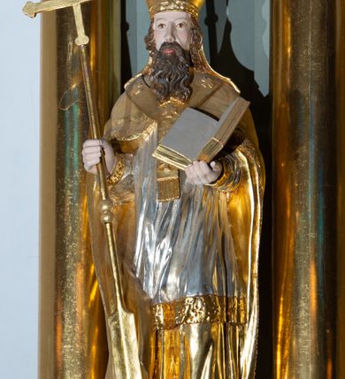 Zdjęcie nr 3: Ołtarz architektoniczny, jednoosiowy, z wydzieloną częścią cokołową i predellą, jednokondygnacyjny, ze zwieńczeniem, dostępny po dwóch kamiennych stopniach. Mensa drewniana z kamiennym portatylem, wsparta na tumbie z neorokokowym kartuszem na froncie. Tabernakulum w formie prostopadłościennej skrzynki, flankowanej z przodu płaskorzeźbionymi kolumienkami, nad nimi rozety; górna krawędź obwiedziona profilowanym gzymsem. Drzwiczki w kształcie formie stojącego prostokąta zamkniętego łukiem półkolistym nadwieszonym, ujęte ramą, z płaskorzeźbionym przedstawieniem kielicha i hostii w polu. Nastawa ujęta dwiema parami kolumn umieszczonych na tle pilastrów podtrzymujących pełne belkowanie, przerwane nad polem środkowym, występujące ponad kolumnami; skrajna para kolumn ustawiona ukośnie względem retabulum. W polu środkowym nisza w kształcie stojącego prostokąta zamkniętego łukiem wklęsło-wypukłym nadwieszonym, ujęta podwójną profilowaną ramą, w niszy obraz Trójcą Święta. Ponad obrazem, na osin neorokokowy kartusz z koroną i inicjałami: KK, otoczony czterema uskrzydlonymi główkami anielskimi. Pomiędzy kolumnami figury św. Wojciecha i św. Stanisława ustawione na konsolach. Zwieńczenie w kształcie aedikuli, ujęte parą łukowato wygiętych pilastrów oraz spływami wolutowymi, na gzymsie koronującym z płaskorzeźbionym Okiem Opatrzności w glorii promienistej oraz z parą wazonów po bokach. W polu owalny obraz z przedstawieniem Ecce Homo ujęty profilowaną ramą. W zwieńczeniu, w osiach kolumn para puttów i para wazonów. Trzony pilastrów i przyłucza w polu głównym dekorowane ornamentem neorokokowym; fryz zdobiony rozetami. Struktura polichromowana w kolorze seledynowym; kolumny, ornamenty i profile złocone.