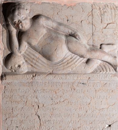 Zdjęcie nr 1: Epitafium w kształcie prostokąta stojącego, ujęte prostokątną profilowaną ramą. Pole w ramie podzielone poziomo na dwie części; w górnym płaskorzeźbiona figura nagiego dziecka leżącego frontalnie, z głową wspartą na prawej ręce, opartej łokciem na czaszce. Prawa rączka ułożona wzdłuż ciała. Prawa noga zgięta w kolanie, lewa wyprostowana, ułożona na prawej. Główka dziecka o okrągłym kształcie, wąskich ustach i okrągłych przymkniętych oczach. Ciało z zaznaczoną muskulaturą, brzuch wydatny. Dziecko ułożone na tkaninie, która przewija się pomiędzy nóżkami. Pod płaskorzeźbą, w dolnej części epitafium inskrypcja łacińska, majuskułą: ILLV[S]TRIS AC MAGNICVS D(OMINVS) D(OMINVS) SEBASTIANVS / LVBOMIIRSKI HAERES IN WISNICZ CASTELLANVS / MALOGOSCE(NSIS) SA(N)DECEN[SIS] SCEPVSIEN[SIS DOBCICIEN[SIS] / CAPITANE(VS) ZVPARI(VS)Q[VE] CRACO(VIENSIS) SEBASTIANO / SEMESTRI FILLIOLO SVO CHARISIMO SIBI IMMA/TVRA MORTE SVPERTO. QVA(N)DO ILLI MAIORA P[RO]PAE/STARE NO(N) LICVIT PARVA(M) HA(E)C TABELLA(M) AMORIS / PATERNI MONVMENTVM. AD POST ERITATE(M) O(MN)IS/ PATRIMONII LOCO EXTARE VOLVIT QVI / OBDORMIVIT ANNO SALVTIS M.DXC IV MEN/SIS [R] EBRVA [RI]I DIE XV REQVIESCAT I(N) D(OMI)NO.