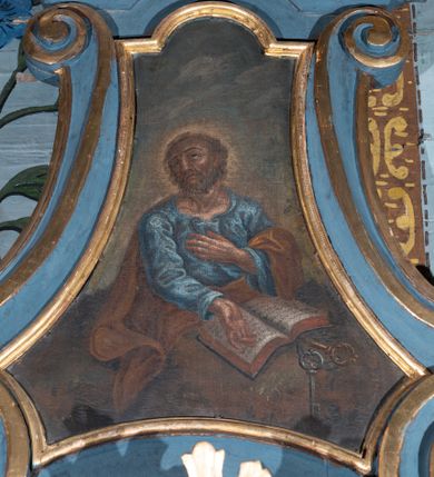 Zdjęcie nr 2: Konfesjonał ustawiony na dwustopniowej podstawie na planie półowalu. Złożony z siedziska z wysokim zapleckiem, zakończonym gzymsem wyłamanym po bokach, dekorowanym kartuszem, ze zwieńczeniem. Siedzisko ujęte dwiema ściankami bocznymi, w górnej połowie przyjmującymi fantazyjną formę rysowaną przez spływy wolutowe, z prześwitami z kratownicą. W partii przedpiersia wypukłe drzwiczki zakończone profilowanym gzymsem. Zaplecek ujęty dwiema ściankami tylnymi w formie spływów wolutowych opadających na półfilary z wazonikami. Zwieńczenie w kształcie zbliżonym do trapezu, flankowane przez spływy wolutowe, zamknięte fragmentem gzymsu przyjmującym formę łuku odcinkowego nadwieszonego, zwieńczonego dużą muszlą. W polu obraz św. Piotra ujęty profilowaną ramą, w kształcie zbliżonym do zwieńczenia. Struktura polichromowana w kolorze niebieskim, profile i ornamentyka złocone, detal srebrzony.