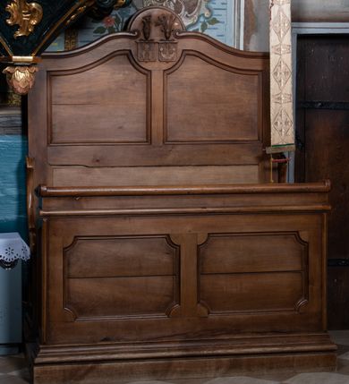 Zdjęcie nr 2: Ławy jednorzędowe, z siedziskiem, wysokim zapleckiem i przedpiersiem, ustawione na niskiej podstawie na planie prostokąta. Zaplecek zakończony zwróconymi ku sobie falistymi wolutami flankującymi owalne pole. W jednej ławie znajduje się w nim tarcza z godłem herbu Prus I, nakryta pięciopałkową koroną. W drugiej poziomo szrafowane tarcze z godłami herbów Pobóg i Sas. Nad nimi umieszczono hełmy z klejnotami herbowymi. Zaplecek i przedpiersie dekorowane płycinami. Siedzisko po bokach ujęte płytkimi ściankami zwieńczonymi spływami wolutowymi. Ławy w całości politurowane. 