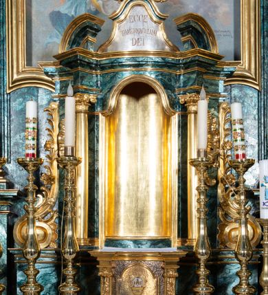 Zdjęcie nr 41: Nastawa ołtarzowa architektoniczna, jednokondygnacyjna ze zwieńczeniem, jednoosiowa z bramkami. Ołtarz prostopadłościenny, murowany, w drewnianej obudowie, z drewnianą mensą. Antepedium ujęte profilowaną ramą; w polu malowana płycina w formie leżącego prostokąta o zaokrąglonych narożach, wypełniona gałązkami różanymi, z akantowo-regencyjnym kartuszem. W narożach antepedium malowane ptaki siedzące na gałązkach. W polu kartusza ukazana scena męczeństwa św. Szymona i św. Judy Tadeusza, na tle pejzażu. Tabernakulum metalowe, prostopadłościenne, flankowane pilastrami w formie spływów wolutowych zdobionych gałązkami róży, zamknięte od góry profilowanym gzymsem. Drzwiczki w kształcie stojącego prostokąta zamkniętego łukiem odcinkowym nadwieszonym; w polu przedstawienie kielicha z hostią. Tabernakulum wprawione w wysoki cokół, na którym stoi tron wystawienia w formie obrotowej niszy, o wypukłej ściance frontowej i ustawionymi pod kątem ściankami bocznymi. Nisza flankowana parą kolumienek i spływów wolutowych dźwigających belkowanie oraz fragmenty przerwanego, półkolistego przyczółka. Na belkowaniu szczyt z rocaillem, z napisem w polu: „ECCE / TABERNACULUM / DEI”. Nastawa ustawiona na dwustrefowym cokole, z wyodrębnionymi czterema prostopadłościanami, w górnej części zdobionym płycinami. Retabulum ujęte parami pilastrów i filarów o kanelowanych trzonach oraz stojącymi przed nimi w układzie schodkowym kolumnami o kapitelach kompozytowych. Podpory dźwigają pełne belkowanie, wyłamane na ich osi, z przerwanym architrawem nad polem środkowym. Na belkowaniu fragmenty falistego, przerwanego przyczółka z figurami aniołów z arma Christi. W polu środkowym wnęka w formie stojącego prostokąta zamkniętego łukiem odcinkowym nadwieszonym, ujęta profilowaną ramą, z obrazem Najświętszej Marii Panny Niepokalanie Poczętej. Nad nią, w polu belkowania rocaille&#039;owy kartusz z napisem „HI / SUNT VIRI / MISERICORDIAE / [...]ccdis 44”. Zwieńczenie w formie zbliżonej do stojącego prostokąta, ujętego pilastrami przechodzącymi w spływy wolutowe, zamkniętego dwoma fragmentami wolutowego gzymsu. Całość zakończona szczytem utworzonym z muszli i zwisów kwiatowych, flankowanym przez dwa wazony. Zwieńczenie ujęte liśćmi palmowymi. W polu obraz z grupą Ukrzyżowania w formie stojącego prostokąta, w profilowanej ramie, dekorowanej rocaille&#039;m. Nastawa flankowana bramkami zwieńczonymi konsolami, na których stoją figury Marii i św. Jana Ewangelisty. Przejścia w formie stojącego prostokąta o wklęsłych górnych narożach, z drzwiczkami z malowanymi przedstawieniami św. Piotra i św. Pawła. Struktura polichromowana na sposób imitujący marmoryzację w kolorze zielono-niebieskim, z laserunkiem, kolumny, ornamentyka i profile złocone, detal srebrzony.