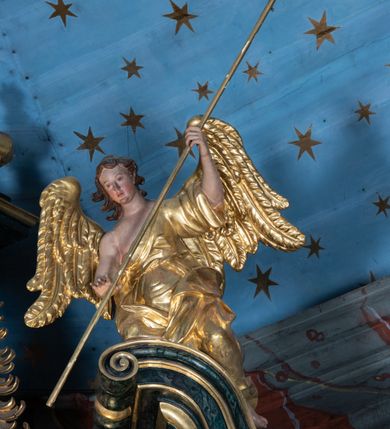 Zdjęcie nr 33: Nastawa ołtarzowa architektoniczna, jednokondygnacyjna ze zwieńczeniem, jednoosiowa z bramkami. Ołtarz prostopadłościenny, murowany, w drewnianej obudowie, z drewnianą mensą. Antepedium ujęte profilowaną ramą; w polu malowana płycina w formie leżącego prostokąta o zaokrąglonych narożach, wypełniona gałązkami różanymi, z akantowo-regencyjnym kartuszem. W narożach antepedium malowane ptaki siedzące na gałązkach. W polu kartusza ukazana scena męczeństwa św. Szymona i św. Judy Tadeusza, na tle pejzażu. Tabernakulum metalowe, prostopadłościenne, flankowane pilastrami w formie spływów wolutowych zdobionych gałązkami róży, zamknięte od góry profilowanym gzymsem. Drzwiczki w kształcie stojącego prostokąta zamkniętego łukiem odcinkowym nadwieszonym; w polu przedstawienie kielicha z hostią. Tabernakulum wprawione w wysoki cokół, na którym stoi tron wystawienia w formie obrotowej niszy, o wypukłej ściance frontowej i ustawionymi pod kątem ściankami bocznymi. Nisza flankowana parą kolumienek i spływów wolutowych dźwigających belkowanie oraz fragmenty przerwanego, półkolistego przyczółka. Na belkowaniu szczyt z rocaillem, z napisem w polu: „ECCE / TABERNACULUM / DEI”. Nastawa ustawiona na dwustrefowym cokole, z wyodrębnionymi czterema prostopadłościanami, w górnej części zdobionym płycinami. Retabulum ujęte parami pilastrów i filarów o kanelowanych trzonach oraz stojącymi przed nimi w układzie schodkowym kolumnami o kapitelach kompozytowych. Podpory dźwigają pełne belkowanie, wyłamane na ich osi, z przerwanym architrawem nad polem środkowym. Na belkowaniu fragmenty falistego, przerwanego przyczółka z figurami aniołów z arma Christi. W polu środkowym wnęka w formie stojącego prostokąta zamkniętego łukiem odcinkowym nadwieszonym, ujęta profilowaną ramą, z obrazem Najświętszej Marii Panny Niepokalanie Poczętej. Nad nią, w polu belkowania rocaille&#039;owy kartusz z napisem „HI / SUNT VIRI / MISERICORDIAE / [...]ccdis 44”. Zwieńczenie w formie zbliżonej do stojącego prostokąta, ujętego pilastrami przechodzącymi w spływy wolutowe, zamkniętego dwoma fragmentami wolutowego gzymsu. Całość zakończona szczytem utworzonym z muszli i zwisów kwiatowych, flankowanym przez dwa wazony. Zwieńczenie ujęte liśćmi palmowymi. W polu obraz z grupą Ukrzyżowania w formie stojącego prostokąta, w profilowanej ramie, dekorowanej rocaille&#039;m. Nastawa flankowana bramkami zwieńczonymi konsolami, na których stoją figury Marii i św. Jana Ewangelisty. Przejścia w formie stojącego prostokąta o wklęsłych górnych narożach, z drzwiczkami z malowanymi przedstawieniami św. Piotra i św. Pawła. Struktura polichromowana na sposób imitujący marmoryzację w kolorze zielono-niebieskim, z laserunkiem, kolumny, ornamentyka i profile złocone, detal srebrzony.