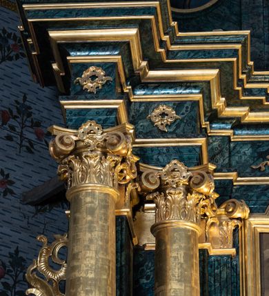 Zdjęcie nr 38: Nastawa ołtarzowa architektoniczna, jednokondygnacyjna ze zwieńczeniem, jednoosiowa z bramkami. Ołtarz prostopadłościenny, murowany, w drewnianej obudowie, z drewnianą mensą. Antepedium ujęte profilowaną ramą; w polu malowana płycina w formie leżącego prostokąta o zaokrąglonych narożach, wypełniona gałązkami różanymi, z akantowo-regencyjnym kartuszem. W narożach antepedium malowane ptaki siedzące na gałązkach. W polu kartusza ukazana scena męczeństwa św. Szymona i św. Judy Tadeusza, na tle pejzażu. Tabernakulum metalowe, prostopadłościenne, flankowane pilastrami w formie spływów wolutowych zdobionych gałązkami róży, zamknięte od góry profilowanym gzymsem. Drzwiczki w kształcie stojącego prostokąta zamkniętego łukiem odcinkowym nadwieszonym; w polu przedstawienie kielicha z hostią. Tabernakulum wprawione w wysoki cokół, na którym stoi tron wystawienia w formie obrotowej niszy, o wypukłej ściance frontowej i ustawionymi pod kątem ściankami bocznymi. Nisza flankowana parą kolumienek i spływów wolutowych dźwigających belkowanie oraz fragmenty przerwanego, półkolistego przyczółka. Na belkowaniu szczyt z rocaillem, z napisem w polu: „ECCE / TABERNACULUM / DEI”. Nastawa ustawiona na dwustrefowym cokole, z wyodrębnionymi czterema prostopadłościanami, w górnej części zdobionym płycinami. Retabulum ujęte parami pilastrów i filarów o kanelowanych trzonach oraz stojącymi przed nimi w układzie schodkowym kolumnami o kapitelach kompozytowych. Podpory dźwigają pełne belkowanie, wyłamane na ich osi, z przerwanym architrawem nad polem środkowym. Na belkowaniu fragmenty falistego, przerwanego przyczółka z figurami aniołów z arma Christi. W polu środkowym wnęka w formie stojącego prostokąta zamkniętego łukiem odcinkowym nadwieszonym, ujęta profilowaną ramą, z obrazem Najświętszej Marii Panny Niepokalanie Poczętej. Nad nią, w polu belkowania rocaille'owy kartusz z napisem „HI / SUNT VIRI / MISERICORDIAE / [...]ccdis 44”. Zwieńczenie w formie zbliżonej do stojącego prostokąta, ujętego pilastrami przechodzącymi w spływy wolutowe, zamkniętego dwoma fragmentami wolutowego gzymsu. Całość zakończona szczytem utworzonym z muszli i zwisów kwiatowych, flankowanym przez dwa wazony. Zwieńczenie ujęte liśćmi palmowymi. W polu obraz z grupą Ukrzyżowania w formie stojącego prostokąta, w profilowanej ramie, dekorowanej rocaille'm. Nastawa flankowana bramkami zwieńczonymi konsolami, na których stoją figury Marii i św. Jana Ewangelisty. Przejścia w formie stojącego prostokąta o wklęsłych górnych narożach, z drzwiczkami z malowanymi przedstawieniami św. Piotra i św. Pawła. Struktura polichromowana na sposób imitujący marmoryzację w kolorze zielono-niebieskim, z laserunkiem, kolumny, ornamentyka i profile złocone, detal srebrzony.