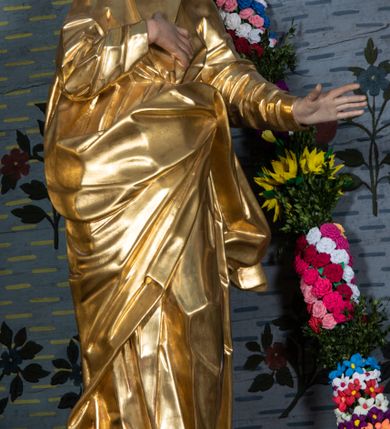 Zdjęcie nr 3: Rzeźba drążona, ustawiona na niskiej podstawie na planie prostokąta. Święty zwrócony w trzech czwartych w prawo, w delikatnym kontrapoście, z lekko uniesioną głową, z lewą ręką wyciągniętą w bok, prawą złożoną na piersi. Twarz ma owalną, z wyraźnie zaznaczoną brodą, o małych oczach zwróconych w górę, z głęboko rzeźbioną górną powieką, dużym nosem i pełnymi ustami z szeroką górną wargą. Włosy ma ciemnobrązowe, silnie kręcone, opadające na ramiona. Ubrany jest w złoconą tunikę z długimi rękawami, przepasaną w talii oraz złocony płaszcz zawiązany z przodu postaci, na lewym biodrze. Na stopach ma złocone sandały. Polichromia naturalistyczna w partiach ciała. 