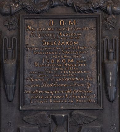 Zdjęcie nr 1: Epitafium w formie tablicy o kształcie stojącego prostokąta ujętej grubą ramą z uszakami w narożach, zamkniętej półkoliście od góry i dołu. W górnej części ramy muszla z podwieszonymi zwisami kwiatowymi, zawiniętymi na palących się pochodniach. Po bokach ramy dwa wąskie wazony, u spodu uskrzydlona klepsydra. Epitafium zwieńczone dekoracją roślinną z krzyżem, na górnych uszakach ustawione dla płaskie wazony, dolne zakończone muszlami. W polu złocony napis „D(EO) O(PTIMO) M(AXIMO) / WALENTEMU LAT 67 † 21 STY(CZNA) 1837. RO[KU] / AGNIESZCE Z KLÓSKÓW / LAT 60 † 15 LUT(EGO) 1834. R(OKU) / SROCZAKOM. / STANISŁAWOWI LAT 58 † 10 WRZ(EŚNIA) 1840 / MARYIANNIE Z SROCZAKÓW / LAT 48 † 8 WRZ(EŚNIA) 1849. / IOBKOM ORAZ / MATEUSZOWI HANUSIAK / LAT 60 † 7 KWI(ETNIA) 1855 RO(KU) / IAKO TEZ TEKLI HANUSIAK ZONIE / IAKUBA ZMAR(ŁEGO) 1863 RO(KU) / W dowód przywiązania ku / swoim Rodzicom i Familiji / ten skromny pomnik poświęca / I PROSI O ZDROWAŚ : KS(IĄDZ) FRANCISZEK / LUDWIK DOMINIKAN ROKU 1865.”