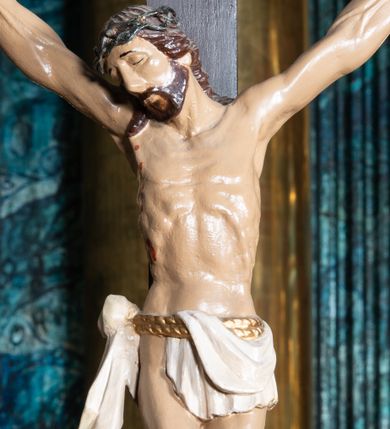 Zdjęcie nr 1: Figura umarłego Chrystusa przybita trzema gwoździami do krzyża o trójlistnym zakończeniu ramion. Ciało Jezusa w dużym zwisie, z ramionami układającymi się na kształt szerokiej litery „V”, z głową opadającą na prawe ramię, ze stopami skrzyżowanymi w układzie prawa na lewą. Twarz ma szczupłą, o zamkniętych oczach i dużym nosie, okoloną krótką brodą i brązowymi włosami opadającymi na ramiona. Na głowie ma koronę cierniową. Ciało szczupłe, ale silnie umięśnione, z podkreślonymi żebrami i mostkiem klatki piersiowej. Perizonium białe, krótkie, zawieszone na podwójnym, złoconym sznurze, odsłaniające prawe biodro, ze zwisem tkaniny na prawym boku. Polichromia ciała naturalistyczna z zaznaczonymi śladami męki. 
