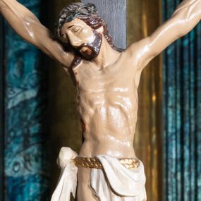 Zdjęcie nr 1: Figura umarłego Chrystusa przybita trzema gwoździami do krzyża o trójlistnym zakończeniu ramion. Ciało Jezusa w dużym zwisie, z ramionami układającymi się na kształt szerokiej litery „V”, z głową opadającą na prawe ramię, ze stopami skrzyżowanymi w układzie prawa na lewą. Twarz ma szczupłą, o zamkniętych oczach i dużym nosie, okoloną krótką brodą i brązowymi włosami opadającymi na ramiona. Na głowie ma koronę cierniową. Ciało szczupłe, ale silnie umięśnione, z podkreślonymi żebrami i mostkiem klatki piersiowej. Perizonium białe, krótkie, zawieszone na podwójnym, złoconym sznurze, odsłaniające prawe biodro, ze zwisem tkaniny na prawym boku. Polichromia ciała naturalistyczna z zaznaczonymi śladami męki. 
