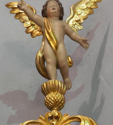 Zdjęcie nr 7: Ołtarz przyścienny, architektoniczny, jednoosiowy z bramkami, jednokondygnacyjny ze zwieńczeniem. Mensa prostopadłościenna, drewniana. Tabernakulum dwukondygnacyjne z tronem wystawienia. Kondygnacja pierwsza ujęta spływami wolutowymi, na drzwiczkach płycina w kształcie stojącego prostokąta zamkniętego łukiem półkolistym z płaskorzeźbionym kielichem z hostią w otoczeniu winorośli. W kondygnacji drugiej tron wystawienia zwieńczony baldachimem wspartym na smukłych kolumienkach z kompozytowymi kapitelami i takich samych pilastrach. Trzony podpór do jednej trzeciej wysokości dekorowane arabeską, powyżej kanelowane. U szczytu baldachimu srebrzony baranek leżący na księdze. Retabulum umieszczone na  wysokim cokole ozdobionym płycinami wypełnionymi dekoracją akantową. Cokół zwieńczony profilowanym gzymsem, na którym ustawione zdwojone podpory: w osiach środkowych złocone pilastry o kanelowanych trzonach dekorowanych w dolnej części arabeską oraz kompozytowych kapitelach; w osiach skrajnych kolumny o analogicznej jak w przypadku pilastrów dekoracji. Pole środkowe ołtarza w kształcie stojącego prostokąta zamkniętego łukiem półkolistym dekorowanym złoconymi kwiatami mieści obraz Matki Boskiej Śnieżnej oraz obraz św. Mikołaja (na zasuwie). Zwieńczenie w formie przyczółka utworzonego z dwóch, przeciwstawnie ustawionych wolut z centralnie umieszczonym złoconym krzyżem oraz ażurową, akantową strukturą; w polu płaskorzeźbiona gołębica Ducha Świętego na tle glorii promienistej. Oś środkowa ujęta dwiema wąskimi płycinami mieszczącymi złocony ornament akantowy. Bramki o formie architektonicznej, jednoosiowe, dwukondygnacyjne ze zwieńczeniem. Kondygnacja pierwsza w formie półkolistej arkady; w zworniku łuku złocona, wolutowa konsolka, na której  ustawiony prostopadłościenny postument z polichromowaną figurą św. Piotra (z lewej) i św. Stanisława (z prawej). Kondygnacja druga ujęta złoconymi korynckimi kolumienkami o skręconych trzonach dźwigającymi łuk półkolisty dekorowany złoconymi, płaskorzeźbionymi kwiatami. W zwieńczeniu pełnoplastyczne, polichromowane figurki puttów ustawione na kulistych konsolkach. Struktura ołtarza polichromowana (w tym marmoryzowana) w dwóch odcieniach jasnej zieleni. Elementy architektoniczne oraz ornamenty złocone.