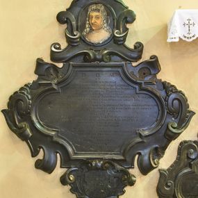 Zdjęcie nr 1: Epitafium z fantazyjnie wyciętą płyciną wpisaną w leżący prostokąt o bokach w kształcie półkolistych, nadwieszonych łukach na wklęsłych uskokach, ujętą uproszczonymi wolutami z chrząstkami. Pod dolną krawędzią kartusz z tarczą z godłami herbów Rawicz, Jastrzębiec, Ramułt, Korybut. Epitafium wieńczy owalne pole z portretem zmarłej otoczone ornamentem kartuszowo-zawijanym i zwieńczone krzyżem wspartym na trzech kulach. Kobieta została przedstawiona w popiersiu, w trzech czwartych, w koronkowym welonie oraz ze sznurem pereł na szyi. Twarz z migdałowatymi oczami zwróconymi w lewo, z długim nosem i wąskimi, szerokimi ustami. W polu inskrypcja „D(EO) O(PTIMO) M(AXIMO) / ET / HOMINVM MEMORIAE / G(E)N(ER)OSA CHRISTINA OLIM G(E)N(E)OSI GABRIELIS / A DEMBIANY DEMBINSKI CVM OLIM G(E)N(ER)OSA ISABELLA / A BELZEC BELZECKA PROCREATA / FILIA [obok wykutE wtórnie Primo CAROLI SZEMBEK 2do G(ENERO)SI ADAMI KOCHANSKI ultimo VOTO G(E)N(ER)OSI MATTHIAE ALEXANDRI A TARNOW TARNOWSKI VENATORIS PAL(A)TINI LANCICZE[SIS] / DVCATVS SEVERIAE CAPITANEI CASTRENSIS LEGITIMA / CONSORS / RELIGIONE IN DEVM CVLTV ET DEVOTIONE IN DEI PARAM AC DEI SANCTOS ERGA MARITVM / AC FILIOS AMORIS INTEGRITATE IN AMICOS AC VICINOS OFFICIO IN OMNES / MORVM PROBITATE INSIGNIS / MVLIER / CVM EXPLESSET ANNOS AETATES SVAE LVI MATRIMONIALIS / COHABITATIONIS XXXX DIE VI MARTII. A(NNO) D(OMINI) M.D.CXCV / SACRAMENTIS BENE MVNITA / IN VILLA GORENICE VITAM / FINIVIT. / LVGENS MARITIVS DESIDERATISSIMAE CONIVGI / HOC POSVIT MONVMENTVM / LECTOR / FIDELIBVS DEFVNCTIS / PRECARE / REQVIEM SEMPITERNAM.”