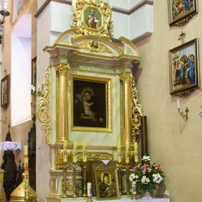 Zdjęcie nr 1: Ołtarz przyścienny, architektoniczny, jednoosiowy, jednokondygnacyjny ze zwieńczeniem. Mensa prostopadłościenna z antepedium drewnianym o dekoracji geometrycznej. W jego centrum okrągła płycina ujęta po bokach dwiema kolejnymi płycinami w kształcie leżącego prostokąta o wklęsłym krótszym boku. Retabulum na wysokim cokole dekorowanym płyciną wypełnioną ornamentem małżowinowo-chrząstkowym, ujęte dwiema złoconymi kolumnami kompozytowymi ustawionymi na wolutowych konsolach i wysuniętymi nieco przed lico ołtarza. Kolumny dźwigają odcinki wyłamanego belkowania z wydatnym gzymsem oraz fragmenty tympanonu zamkniętego łukiem odcinkowym. W zwieńczeniu płaskorzeźbiona, uskrzydlona główka anielska na tle łuku odcinkowego oraz powyżej płaskorzeźbione popiersie św. Jana Chrzciciela w ośmiobocznej, złoconej ramie ujętej ażurową strukturą ze złoconego ornamentu małżowinowo-chrząstkowego; całość zwieńczona złoconym krzyżem o trójlistnie zamkniętych ramionach. W głównym polu ołtarza płycina w kształcie stojącego prostokąta mieszcząca barokowy obraz św. Antoniego Padewskiego (1691) w złoconej ramie. Ołtarz ujęty po bokach złoconymi, ażurowymi uszami utworzonymi z ornamentu małżowinowo-chrząstkowego. Struktura ołtarza polichromowana (w tym marmoryzowana) w odcieniach jasnej zieleni; detale elementów architektonicznych oraz ornamenty złocone.