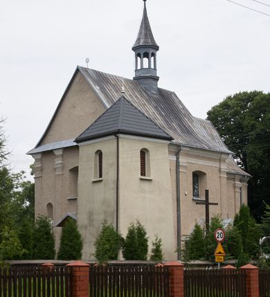 Zdjęcie nr 5: Kościół parafialny pw. św. Mikołaja w Gorenicach to niewielkich rozmiarów orientowana, murowana z cegły i tynkowana budowla na rzucie prostokąta z węższym i nieco niższym prezbiterium, zamkniętym półokrągłą apsydą. Od północy do prezbiterium przylega zakrystia, założona na planie prostokąta. Nad zakrystią znajduje się skarbczyk. Od południa do nawy przylega prostokątna kruchta. Dwuprzęsłowa nawa nakryta jest dachem dwuspadowym z ośmioboczną wieżyczką na sygnaturkę z glorietą zwieńczoną krzyżem. Prezbiterium jednoprzęsłowe nakrywa dach trójpołaciowy, zakrystię dach dwuspadowy. Pokrycie dachowe jest w całości blaszane. Kościół wzniesiono na niewielkim cokole. Artykulację ścian nawy i prezbiterium przeprowadzono przy pomocy monumentalnych, toskańskich pilastrów umieszczonych na wydatnych cokołach. Elewacje korpusu nawowego wieńczy gzyms kordonowy. Prezbiterium zwieńczone gzymsem profilowanym, poniżej którego znajduje się dekoracja w formie wałka. Fasada kościoła, trójosiowa i jednokondygnacyjna, rozczłonkowana jest monumentalnymi, toskańskimi pilastrami w wielkim porządku. Wieńczy ją trójkątna ściana szczytowa. W dwóch trzecich wysokości umieszczono daszek kapnikowy. Na osi głównej elewacji znajduje się prostokątny portal w formie półkolistej arkady zwieńczonej przerwanym, trójkątnym przyczółkiem. Odrzwia portalu dekorowane są pseudokanelowaniem wykonanym w technice płaskiego reliefu. Lico łuku wypełnia geometryczna plecionka, w zworniku znajduje się liść akantu. Przyłucza wypełnia ornament kwiatowy. Wewnątrz przyczółka na niewielkiej konsoli umieszczono kamienny, płaskorzeźbiony kartusz z herbami Rola i Ostoja. Nad portalem znajduje się współczesny, dwuspadowy daszek, powyżej którego rozglifione okno, prostokątne, zamknięte łukiem odcinkowym. W osiach bocznych fasady znajdują się prostokątne nisze z pełnoplastycznymi rzeźbami św. Antoniego i św. Mikołaja. Kruchtę południową ujmują dwa pilastry wspierające przerwany gzyms, zwieńczony trójkątnym przyczółkiem. Na osi znajduje się prostokątne wejście zamknięte łukiem odcinkowym; w ścianie zachodniej prostokątne okno. Okna w nawie i prezbiterium prostokątne, zamknięte łukiem odcinkowym. W zakrystii i w pomieszczeniu nad zakrystią okna w ścianie wschodniej. Korpus kościoła jednonawowy i dwuprzęsłowy nakryty jest sklepieniem kolebkowym z lunetami, na gurtach. Prezbiterium od nawy oddziela półokrągły łuk tęczowy wsparty na pełnym belkowaniu. W narożach nawy głównej przerwane pilastry. Nad apsydą znajduje się koncha, w zakrystii sklepienie kolebkowo-krzyżowe, w pomieszczeniu nad zakrystią kolebkowe z lunetami. Kruchta nakryta sufitem. Drzwi główne na osi kościoła, drewniane, zamknięte łukiem półokrągłym. W pierwszym przęśle drzwi do kruchty w niszy prostokątnej, zamkniętej łukiem odcinkowym. W ścianie prezbiterium drzwi do zakrystii prostokątne, w kamiennym portalu z uszakami, zwieńczonym silnie wysuniętym profilowanym gzymsem. W drugim przęśle chór muzyczny, drewniany, z balustradą. Balustrada rozczłonkowana pilastrami, na wyłamanym cokole, zakończona pulpitem. W narożniku południowo-zachodnim korpusu schody drewniane, załamujące się, prowadzące na chór. Posadzka z płyt wykonanych w technice lastrico, niejednorodna, marmurowa. Plac przykościelny otoczony niewysokim, kamiennym murem. W jego południowo-zachodniej części znajduje się wolnostojąca dzwonnica, murowana z cegły, tynkowana na planie kwadratu. W każdej ścianie okna prostokątne, zamknięte łukiem odcinkowym. Dzwonnica z dachem czterospadowym, krytym blachą. Na cmentarzu dwa nagrobki z początku XX wieku.  
