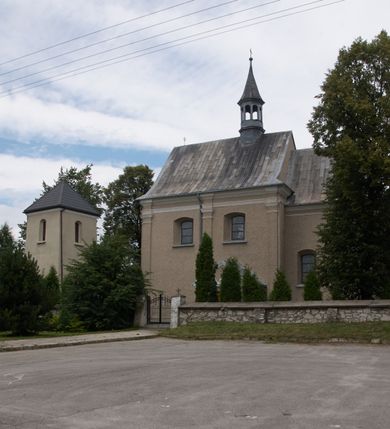 Zdjęcie nr 9: Kościół parafialny pw. św. Mikołaja w Gorenicach to niewielkich rozmiarów orientowana, murowana z cegły i tynkowana budowla na rzucie prostokąta z węższym i nieco niższym prezbiterium, zamkniętym półokrągłą apsydą. Od północy do prezbiterium przylega zakrystia, założona na planie prostokąta. Nad zakrystią znajduje się skarbczyk. Od południa do nawy przylega prostokątna kruchta. Dwuprzęsłowa nawa nakryta jest dachem dwuspadowym z ośmioboczną wieżyczką na sygnaturkę z glorietą zwieńczoną krzyżem. Prezbiterium jednoprzęsłowe nakrywa dach trójpołaciowy, zakrystię dach dwuspadowy. Pokrycie dachowe jest w całości blaszane. Kościół wzniesiono na niewielkim cokole. Artykulację ścian nawy i prezbiterium przeprowadzono przy pomocy monumentalnych, toskańskich pilastrów umieszczonych na wydatnych cokołach. Elewacje korpusu nawowego wieńczy gzyms kordonowy. Prezbiterium zwieńczone gzymsem profilowanym, poniżej którego znajduje się dekoracja w formie wałka. Fasada kościoła, trójosiowa i jednokondygnacyjna, rozczłonkowana jest monumentalnymi, toskańskimi pilastrami w wielkim porządku. Wieńczy ją trójkątna ściana szczytowa. W dwóch trzecich wysokości umieszczono daszek kapnikowy. Na osi głównej elewacji znajduje się prostokątny portal w formie półkolistej arkady zwieńczonej przerwanym, trójkątnym przyczółkiem. Odrzwia portalu dekorowane są pseudokanelowaniem wykonanym w technice płaskiego reliefu. Lico łuku wypełnia geometryczna plecionka, w zworniku znajduje się liść akantu. Przyłucza wypełnia ornament kwiatowy. Wewnątrz przyczółka na niewielkiej konsoli umieszczono kamienny, płaskorzeźbiony kartusz z herbami Rola i Ostoja. Nad portalem znajduje się współczesny, dwuspadowy daszek, powyżej którego rozglifione okno, prostokątne, zamknięte łukiem odcinkowym. W osiach bocznych fasady znajdują się prostokątne nisze z pełnoplastycznymi rzeźbami św. Antoniego i św. Mikołaja. Kruchtę południową ujmują dwa pilastry wspierające przerwany gzyms, zwieńczony trójkątnym przyczółkiem. Na osi znajduje się prostokątne wejście zamknięte łukiem odcinkowym; w ścianie zachodniej prostokątne okno. Okna w nawie i prezbiterium prostokątne, zamknięte łukiem odcinkowym. W zakrystii i w pomieszczeniu nad zakrystią okna w ścianie wschodniej. Korpus kościoła jednonawowy i dwuprzęsłowy nakryty jest sklepieniem kolebkowym z lunetami, na gurtach. Prezbiterium od nawy oddziela półokrągły łuk tęczowy wsparty na pełnym belkowaniu. W narożach nawy głównej przerwane pilastry. Nad apsydą znajduje się koncha, w zakrystii sklepienie kolebkowo-krzyżowe, w pomieszczeniu nad zakrystią kolebkowe z lunetami. Kruchta nakryta sufitem. Drzwi główne na osi kościoła, drewniane, zamknięte łukiem półokrągłym. W pierwszym przęśle drzwi do kruchty w niszy prostokątnej, zamkniętej łukiem odcinkowym. W ścianie prezbiterium drzwi do zakrystii prostokątne, w kamiennym portalu z uszakami, zwieńczonym silnie wysuniętym profilowanym gzymsem. W drugim przęśle chór muzyczny, drewniany, z balustradą. Balustrada rozczłonkowana pilastrami, na wyłamanym cokole, zakończona pulpitem. W narożniku południowo-zachodnim korpusu schody drewniane, załamujące się, prowadzące na chór. Posadzka z płyt wykonanych w technice lastrico, niejednorodna, marmurowa. Plac przykościelny otoczony niewysokim, kamiennym murem. W jego południowo-zachodniej części znajduje się wolnostojąca dzwonnica, murowana z cegły, tynkowana na planie kwadratu. W każdej ścianie okna prostokątne, zamknięte łukiem odcinkowym. Dzwonnica z dachem czterospadowym, krytym blachą. Na cmentarzu dwa nagrobki z początku XX wieku.  
