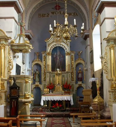 Zdjęcie nr 14: Kościół parafialny pw. św. Mikołaja w Gorenicach to niewielkich rozmiarów orientowana, murowana z cegły i tynkowana budowla na rzucie prostokąta z węższym i nieco niższym prezbiterium, zamkniętym półokrągłą apsydą. Od północy do prezbiterium przylega zakrystia, założona na planie prostokąta. Nad zakrystią znajduje się skarbczyk. Od południa do nawy przylega prostokątna kruchta. Dwuprzęsłowa nawa nakryta jest dachem dwuspadowym z ośmioboczną wieżyczką na sygnaturkę z glorietą zwieńczoną krzyżem. Prezbiterium jednoprzęsłowe nakrywa dach trójpołaciowy, zakrystię dach dwuspadowy. Pokrycie dachowe jest w całości blaszane. Kościół wzniesiono na niewielkim cokole. Artykulację ścian nawy i prezbiterium przeprowadzono przy pomocy monumentalnych, toskańskich pilastrów umieszczonych na wydatnych cokołach. Elewacje korpusu nawowego wieńczy gzyms kordonowy. Prezbiterium zwieńczone gzymsem profilowanym, poniżej którego znajduje się dekoracja w formie wałka. Fasada kościoła, trójosiowa i jednokondygnacyjna, rozczłonkowana jest monumentalnymi, toskańskimi pilastrami w wielkim porządku. Wieńczy ją trójkątna ściana szczytowa. W dwóch trzecich wysokości umieszczono daszek kapnikowy. Na osi głównej elewacji znajduje się prostokątny portal w formie półkolistej arkady zwieńczonej przerwanym, trójkątnym przyczółkiem. Odrzwia portalu dekorowane są pseudokanelowaniem wykonanym w technice płaskiego reliefu. Lico łuku wypełnia geometryczna plecionka, w zworniku znajduje się liść akantu. Przyłucza wypełnia ornament kwiatowy. Wewnątrz przyczółka na niewielkiej konsoli umieszczono kamienny, płaskorzeźbiony kartusz z herbami Rola i Ostoja. Nad portalem znajduje się współczesny, dwuspadowy daszek, powyżej którego rozglifione okno, prostokątne, zamknięte łukiem odcinkowym. W osiach bocznych fasady znajdują się prostokątne nisze z pełnoplastycznymi rzeźbami św. Antoniego i św. Mikołaja. Kruchtę południową ujmują dwa pilastry wspierające przerwany gzyms, zwieńczony trójkątnym przyczółkiem. Na osi znajduje się prostokątne wejście zamknięte łukiem odcinkowym; w ścianie zachodniej prostokątne okno. Okna w nawie i prezbiterium prostokątne, zamknięte łukiem odcinkowym. W zakrystii i w pomieszczeniu nad zakrystią okna w ścianie wschodniej. Korpus kościoła jednonawowy i dwuprzęsłowy nakryty jest sklepieniem kolebkowym z lunetami, na gurtach. Prezbiterium od nawy oddziela półokrągły łuk tęczowy wsparty na pełnym belkowaniu. W narożach nawy głównej przerwane pilastry. Nad apsydą znajduje się koncha, w zakrystii sklepienie kolebkowo-krzyżowe, w pomieszczeniu nad zakrystią kolebkowe z lunetami. Kruchta nakryta sufitem. Drzwi główne na osi kościoła, drewniane, zamknięte łukiem półokrągłym. W pierwszym przęśle drzwi do kruchty w niszy prostokątnej, zamkniętej łukiem odcinkowym. W ścianie prezbiterium drzwi do zakrystii prostokątne, w kamiennym portalu z uszakami, zwieńczonym silnie wysuniętym profilowanym gzymsem. W drugim przęśle chór muzyczny, drewniany, z balustradą. Balustrada rozczłonkowana pilastrami, na wyłamanym cokole, zakończona pulpitem. W narożniku południowo-zachodnim korpusu schody drewniane, załamujące się, prowadzące na chór. Posadzka z płyt wykonanych w technice lastrico, niejednorodna, marmurowa. Plac przykościelny otoczony niewysokim, kamiennym murem. W jego południowo-zachodniej części znajduje się wolnostojąca dzwonnica, murowana z cegły, tynkowana na planie kwadratu. W każdej ścianie okna prostokątne, zamknięte łukiem odcinkowym. Dzwonnica z dachem czterospadowym, krytym blachą. Na cmentarzu dwa nagrobki z początku XX wieku.  
