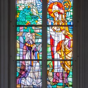 Zdjęcie nr 1: Witraż w zachodnim przęśle nawy, w oknie południowym. Kompozycja w kształcie stojącego prostokąta zamkniętego łukiem ostrym, przedzielona pionową laską na dwie części, u góry z maswerkiem o motywie czteroliścia. Witraż przedstawia scenę wskrzeszenia Piotrowina przez świętego Stanisława Szczepanowskiego. W prawej części św. Stanisław w stroju biskupim, w lewej powstający z grobu Piotrowin. Powyżej banderola z napisem: ŚWIĘTY STANISŁAW, ozdobiona stylizowanymi kwiatami. W górnej części dwa ustawione antytetycznie anioły trzymające na rękach mandorle z atrybutami: mieczem i palmą. W polu czteroliścia herb miasta Kraków. W dolnej części medalion z rozchylonym kwiatem o rozchylonych płatkach otoczony stylizowaną wicią roślinną z białymi kwiatami. Na drugim planie pejzaż z średniowiecznym miastem w tle. Postacie uproszczone, zgeometryzowane, modelunek linearny. Kolory kontrastowe, przewaga zieleni. W prawym dolnym narożu sygnatury: KRAKOWSKI ZAKŁAD WITRAŻY KRASIŃSKIEGO NR. 23, oraz: ROK 1977 / PROJEKTOWAŁ  ART. MAL. BOLESŁAW SZPRECHT.