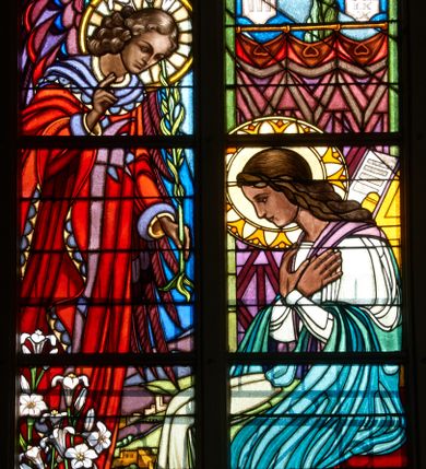 Zdjęcie nr 1: Witraż w trzecim przęśle od zachodu, w oknie południowym. Kompozycja w kształcie stojącego prostokąta zamkniętego łukiem ostrym, podzielona pionową laską na dwie części, u góry z maswerkiem o motywie czteroliścia. W prawej części ukazana Maria siedząca z dłońmi złożonymi na piersi. W lewej archanioł Gabriel w czerwonej szacie, z fioletowymi skrzydłami i lilią w lewej ręce; prawą rękę wznosi w geście pozdrowienia. Maria ubrana w zielono- błękitną szatę. Nad głową anioła Gołębica Ducha Świętego, od której spływają promienie. W tle wnętrze z fioletową kotarą, nad którą wiszą tablice Dziesięciu Przykazań i świecznik trójramienny. W polu czteroliścia u góry splecione litery imienia Maria. U dołu dekoracyjna rama wypełniona ornamentem geometrycznym, wewnątrz której dwa napisy: ANDREAS ET HEDWIGIS GŁOWNIA / CURA PAROCHI JACOBI MORAJKA / FUNDAVERUNT A. D. 1937; SUMPTIBUS PAROCHIANIS/ ANNO DOMINI- 1955/ RENOVATUM. Żywa kolorystyka, silny linearyzm, płaski modelunek.