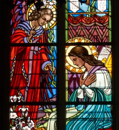 Zdjęcie nr 2: Witraż w trzecim przęśle od zachodu, w oknie południowym. Kompozycja w kształcie stojącego prostokąta zamkniętego łukiem ostrym, podzielona pionową laską na dwie części, u góry z maswerkiem o motywie czteroliścia. W prawej części ukazana Maria siedząca z dłońmi złożonymi na piersi. W lewej archanioł Gabriel w czerwonej szacie, z fioletowymi skrzydłami i lilią w lewej ręce; prawą rękę wznosi w geście pozdrowienia. Maria ubrana w zielono- błękitną szatę. Nad głową anioła Gołębica Ducha Świętego, od której spływają promienie. W tle wnętrze z fioletową kotarą, nad którą wiszą tablice Dziesięciu Przykazań i świecznik trójramienny. W polu czteroliścia u góry splecione litery imienia Maria. U dołu dekoracyjna rama wypełniona ornamentem geometrycznym, wewnątrz której dwa napisy: ANDREAS ET HEDWIGIS GŁOWNIA / CURA PAROCHI JACOBI MORAJKA / FUNDAVERUNT A. D. 1937; SUMPTIBUS PAROCHIANIS/ ANNO DOMINI- 1955/ RENOVATUM. Żywa kolorystyka, silny linearyzm, płaski modelunek.