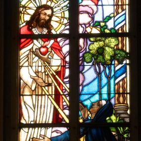 Zdjęcie nr 1: Witraż w oknie południowym prezbiterium, w kształcie stojącego prostokąta zamkniętego łukiem ostrym. Kompozycja podzielona pionową laską na dwie części, u góry z maswerkiem o motywie czworoliścia. W centrum przedstawienie Chrystusa ukazującego się świętej Małgorzacie Marii Alacoque. Ubrany w białą szatę oraz czerwony płaszcz, stoi na mensie ołtarza, którego antependium ozdobione medalionem z literami: IHS. W ręku trzyma gorejące serce. Poniżej klęczy święta ubrana w czarny habit wizytki, u jej stop leży księga. Scena ukazana we wnętrzu. W górnej części kompozycji putta na chmurach. W polu czworoliścia Oko Opatrzności. W dolnej części kompozycji napis: PIAE MEMORIAE AEMILIAE ET STEPHANIAE DE KASPRZAK ORŁYŃSKIE AMANS SOROR HEDWIGIS FUNDAVIT A.D. 1938 PROCURA PAROCHI JACOBI MORAJKA. Całość stylizowana na gobelin z dekoracyjnymi chwostami u dołu.