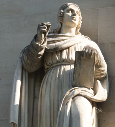 Zdjęcie nr 1: Na konsoli na rzucie ośmioboku, wmurowanej w fasadę, podpieranej przez orła z rozpostartymi skrzydłami, stoi święty ukazany w całej postaci, w kontrapoście, ubrany w długą suknię przepasaną pasem na biodrach i płaszcz, okrywający prawe ramię i dolną część lewej nogi, z prawą ręką uniesioną, z lewą przytrzymującą księgę wspartą na udzie. 

