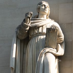 Zdjęcie nr 1: Na konsoli na rzucie ośmioboku, wmurowanej w fasadę, podpieranej przez orła z rozpostartymi skrzydłami, stoi święty ukazany w całej postaci, w kontrapoście, ubrany w długą suknię przepasaną pasem na biodrach i płaszcz, okrywający prawe ramię i dolną część lewej nogi, z prawą ręką uniesioną, z lewą przytrzymującą księgę wspartą na udzie. 

