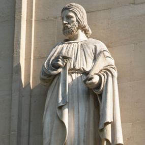 Zdjęcie nr 1: Na konsoli na rzucie ośmioboku, wmurowanej w fasadę kościoła, z uskrzydloną główka anioła, stoi święty ujęty w całej postaci, frontalnie, ubrany długą suknię przepasaną w pasie, o miękkich, pionowych fałdach i płaszcz przerzucony na plecy i oba ramiona, z księgą w lewej dłoni. Twarz oddana sumarycznie, okolona kręconą, krótką brodą, włosy sięgajace szyi. 