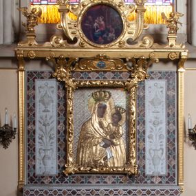 Zdjęcie nr 1: Ołtarza architektoniczny, przyścienny, jednokondygnacyjny, trójosiowy, ze zwieńczeniem. Mensa skrzyniowa z wydzielonym cokołem i gzymsem; antependium zdobione trzema dużymi, inkrustowanymi rozetami, flankowane po bokach rzeźbami umieszczonymi w arkadowych, ostrołukowych, wspartych na kolumienkach niszach. Retabulum prostokątne, płaskie, trójdzielne. W polu środkowym obraz Matki Boskiej z Dzieciątkiem. Po bokach obrazu prostokątne płyciny z dekoracją w formie wazonów z kwiatami i wstęgami. Tło retabulum wypełnione trójbarwną (niebieską, zieloną i bordową) inkrustacją o motywach czteroliścia. W zwieńczeniu ołtarza kolisty obraz Święta Rodzina, ujęty ażurową, drewnianą ramą (pochodzącą zapewne ze starszego ołtarza) o motywach okuciowych (pierwsza połowa XVII wieku). Po jego bokach skrzydlate aniołki ustawione na postumentach.