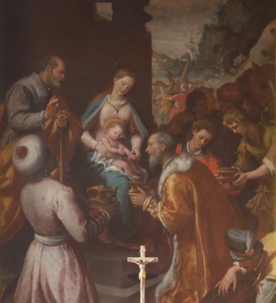 Zdjęcie nr 2: W środku kompozycji Maria w jasnej sukni, z niebieskim płaszczem narzuconym na ramiona i odkrytą głową siedzi, trzymając nagie Dzieciątko na kolanach. Obok niej po lewej stronie stoi św. Józef zwrócony profilem, wsparty na lasce. Na pierwszym planie Trzej Królowie: z lewej Murzyn w turbanie odwrócony tyłem klęczy, podając szkatułkę, pośrodku, zwrócony profilem klęczy brodaty monarcha w aksamitnym złotym płaszczu i podaje Dzieciątku naczynie. Trzeci król w czapce z piórem ukazuje się w prawym dolnym narożniku, pochylony otwiera szkatułę z darami. Na drugim planie po prawej grupa dwóch giermków z naczyniem. W tle po lewej architektura ruin, po prawej daleki „romantyczny” krajobraz. Koloryt soczysty, odpowiadający w tonacji wieczornej porze sceny.