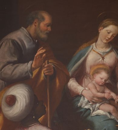 Zdjęcie nr 9: W środku kompozycji Maria w jasnej sukni, z niebieskim płaszczem narzuconym na ramiona i odkrytą głową siedzi, trzymając nagie Dzieciątko na kolanach. Obok niej po lewej stronie stoi św. Józef zwrócony profilem, wsparty na lasce. Na pierwszym planie Trzej Królowie: z lewej Murzyn w turbanie odwrócony tyłem klęczy, podając szkatułkę, pośrodku, zwrócony profilem klęczy brodaty monarcha w aksamitnym złotym płaszczu i podaje Dzieciątku naczynie. Trzeci król w czapce z piórem ukazuje się w prawym dolnym narożniku, pochylony otwiera szkatułę z darami. Na drugim planie po prawej grupa dwóch giermków z naczyniem. W tle po lewej architektura ruin, po prawej daleki „romantyczny” krajobraz. Koloryt soczysty, odpowiadający w tonacji wieczornej porze sceny.