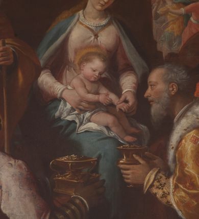 Zdjęcie nr 12: W środku kompozycji Maria w jasnej sukni, z niebieskim płaszczem narzuconym na ramiona i odkrytą głową siedzi, trzymając nagie Dzieciątko na kolanach. Obok niej po lewej stronie stoi św. Józef zwrócony profilem, wsparty na lasce. Na pierwszym planie Trzej Królowie: z lewej Murzyn w turbanie odwrócony tyłem klęczy, podając szkatułkę, pośrodku, zwrócony profilem klęczy brodaty monarcha w aksamitnym złotym płaszczu i podaje Dzieciątku naczynie. Trzeci król w czapce z piórem ukazuje się w prawym dolnym narożniku, pochylony otwiera szkatułę z darami. Na drugim planie po prawej grupa dwóch giermków z naczyniem. W tle po lewej architektura ruin, po prawej daleki „romantyczny” krajobraz. Koloryt soczysty, odpowiadający w tonacji wieczornej porze sceny.