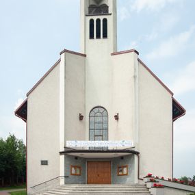 Zdjęcie nr 1: Kościół Podwyższenia Krzyża Świętego w Janowicach jest zlokalizowany na niewielkim wzniesieniu, w centrum prostokątnego placu otoczonego murowanym ogrodzeniem podzielonym na przęsła. W południowo-zachodnim narożu terenu przykościelnego usytuowana jest parawanowa dzwonnica. Kościół to budowla murowana z cegły, jednonawowa na planie krzyża łacińskiego. Do czteroprzęsłowej nawy przylega wyniesione na czterostopniowym podwyższeniu prezbiterium zamknięte prostą ścianą. Do prezbiterium od zachodu przylega zakrystia na planie zbliżonym do litery „L”, od wschodu aneks na analogicznym planie. Zakrystia skomunikowana jest z dobudowaną od południa dwukondygnacyjną i podpiwniczoną  plebanią. Wnętrze świątyni przekryte jest płaskim stropem o konstrukcji żelbetowej. Ściany w dolnej części artykułowane są za pomocą boazerii, w wyższych partiach podziały kontynuowane są w polichromii. W górnych partiach ścian (poza prezbiterium) znajdują się ukośne sufity, w nawie dodatkowo poprzedzone profilowanym gzymsem. W najwyższym rzędzie płycin mieszczą się płaskorzeźbione, stylizowane rozety z motywami geometrycznymi; analogiczne rozety zdobią parapet chóru muzycznego. Nawę doświetlają okna w kształcie stojącego prostokąta zamkniętego półkoliście: po jednym w przęsłach od drugiego do czwartego i jedno nieco większe, ponad chórem w ścianie północnej. W ścianach zamykających transept znajdują się po trzy duże otwory okienne złożone z umieszczonego po środku dużego okna w kształcie odwróconej podkowy oraz flankujących go mniejszych okien w kształcie stojącego prostokąta zamkniętego półkoliście. Główne wejście do świątyni znajduje się na osi budynku, w ścianie północnej, wejście boczne usytuowane jest w północnej ścianie zachodniego ramienia transeptu. Na szerokości pierwszego od północy przęsła nawy znajduje się chór muzyczny o konstrukcji żelbetowej, wsparty na dwóch filarach. Pod nim mieści się kruchta. Parapet chóru muzycznego jest murowany, prosty, w części środkowej trójbocznie wyłamany do wnętrza kościoła. W osi środkowej trójdzielnej fasady kościoła umieszczona wieża na planie kwadratu, nieco cofnięta w stosunku do lica elewacji, którą ujmują ukośnie ustawione ściany. Wejście do świątyni znajduje się na osi fasady. Jest zadaszone płaskim dachem; prowadzą do niego siedmiostopniowe schody. Od strony zachodniej zlokalizowany jest podjazd dla niepełnosprawnych. Otwór wejściowy ma kształt prostokąta, wewnątrz znajdują się drewniane, dwuskrzydłowe drzwi. Powyżej umiejscowione jest duże okno w kształcie stojącego prostokąta zamkniętego półkoliście. W górnej części wieży umieszczono trzy wysmukłe okna zamknięte półkoliście. W zwieńczeniu mieści się ażurowy prześwit pełniący funkcję tarasu widokowego. Wieżę wieńczy hełm w kształcie wysmukłego ostrosłupa z krzyżem. Elewacje boczne pozbawione są dekoracji.


