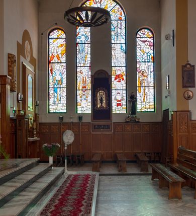 Zdjęcie nr 3: Kościół Podwyższenia Krzyża Świętego w Janowicach jest zlokalizowany na niewielkim wzniesieniu, w centrum prostokątnego placu otoczonego murowanym ogrodzeniem podzielonym na przęsła. W południowo-zachodnim narożu terenu przykościelnego usytuowana jest parawanowa dzwonnica. Kościół to budowla murowana z cegły, jednonawowa na planie krzyża łacińskiego. Do czteroprzęsłowej nawy przylega wyniesione na czterostopniowym podwyższeniu prezbiterium zamknięte prostą ścianą. Do prezbiterium od zachodu przylega zakrystia na planie zbliżonym do litery „L”, od wschodu aneks na analogicznym planie. Zakrystia skomunikowana jest z dobudowaną od południa dwukondygnacyjną i podpiwniczoną  plebanią. Wnętrze świątyni przekryte jest płaskim stropem o konstrukcji żelbetowej. Ściany w dolnej części artykułowane są za pomocą boazerii, w wyższych partiach podziały kontynuowane są w polichromii. W górnych partiach ścian (poza prezbiterium) znajdują się ukośne sufity, w nawie dodatkowo poprzedzone profilowanym gzymsem. W najwyższym rzędzie płycin mieszczą się płaskorzeźbione, stylizowane rozety z motywami geometrycznymi; analogiczne rozety zdobią parapet chóru muzycznego. Nawę doświetlają okna w kształcie stojącego prostokąta zamkniętego półkoliście: po jednym w przęsłach od drugiego do czwartego i jedno nieco większe, ponad chórem w ścianie północnej. W ścianach zamykających transept znajdują się po trzy duże otwory okienne złożone z umieszczonego po środku dużego okna w kształcie odwróconej podkowy oraz flankujących go mniejszych okien w kształcie stojącego prostokąta zamkniętego półkoliście. Główne wejście do świątyni znajduje się na osi budynku, w ścianie północnej, wejście boczne usytuowane jest w północnej ścianie zachodniego ramienia transeptu. Na szerokości pierwszego od północy przęsła nawy znajduje się chór muzyczny o konstrukcji żelbetowej, wsparty na dwóch filarach. Pod nim mieści się kruchta. Parapet chóru muzycznego jest murowany, prosty, w części środkowej trójbocznie wyłamany do wnętrza kościoła. W osi środkowej trójdzielnej fasady kościoła umieszczona wieża na planie kwadratu, nieco cofnięta w stosunku do lica elewacji, którą ujmują ukośnie ustawione ściany. Wejście do świątyni znajduje się na osi fasady. Jest zadaszone płaskim dachem; prowadzą do niego siedmiostopniowe schody. Od strony zachodniej zlokalizowany jest podjazd dla niepełnosprawnych. Otwór wejściowy ma kształt prostokąta, wewnątrz znajdują się drewniane, dwuskrzydłowe drzwi. Powyżej umiejscowione jest duże okno w kształcie stojącego prostokąta zamkniętego półkoliście. W górnej części wieży umieszczono trzy wysmukłe okna zamknięte półkoliście. W zwieńczeniu mieści się ażurowy prześwit pełniący funkcję tarasu widokowego. Wieżę wieńczy hełm w kształcie wysmukłego ostrosłupa z krzyżem. Elewacje boczne pozbawione są dekoracji.


